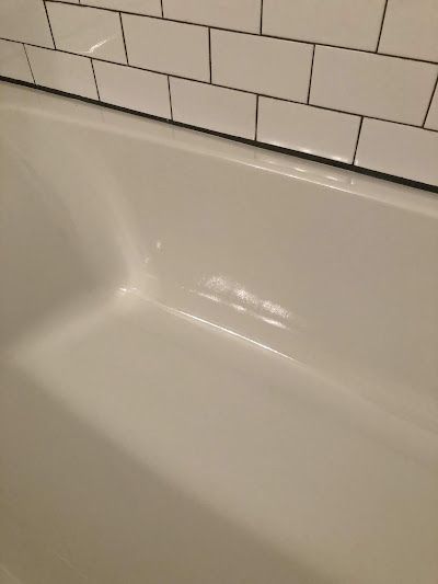 White bathtub with white subway tile in the background.