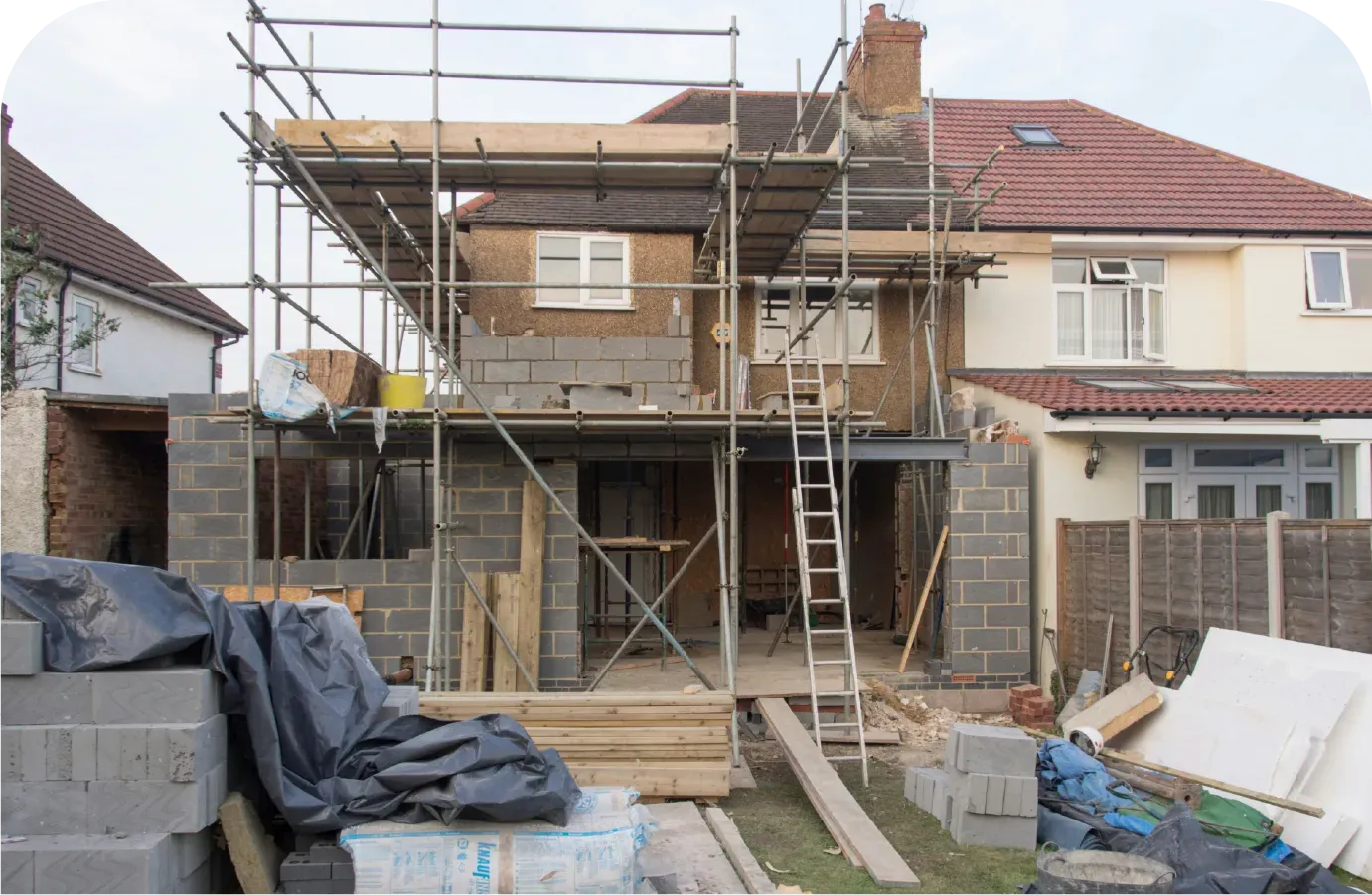 Rear house under construction with scaffolding and building materials.