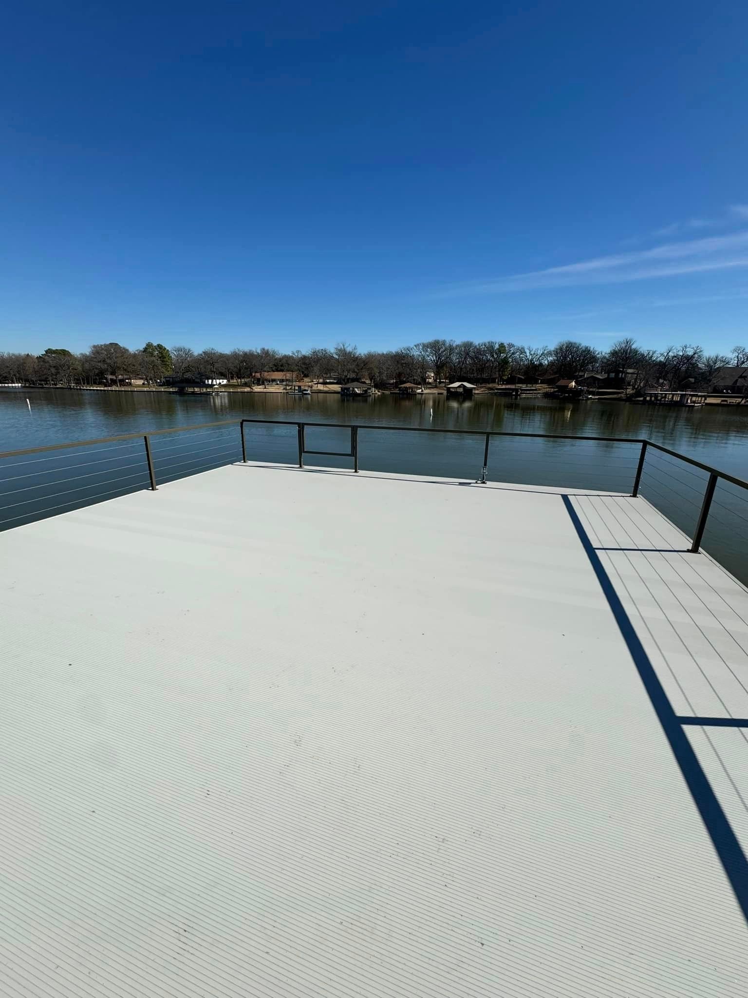 A dock with a view of a lake on a sunny day.