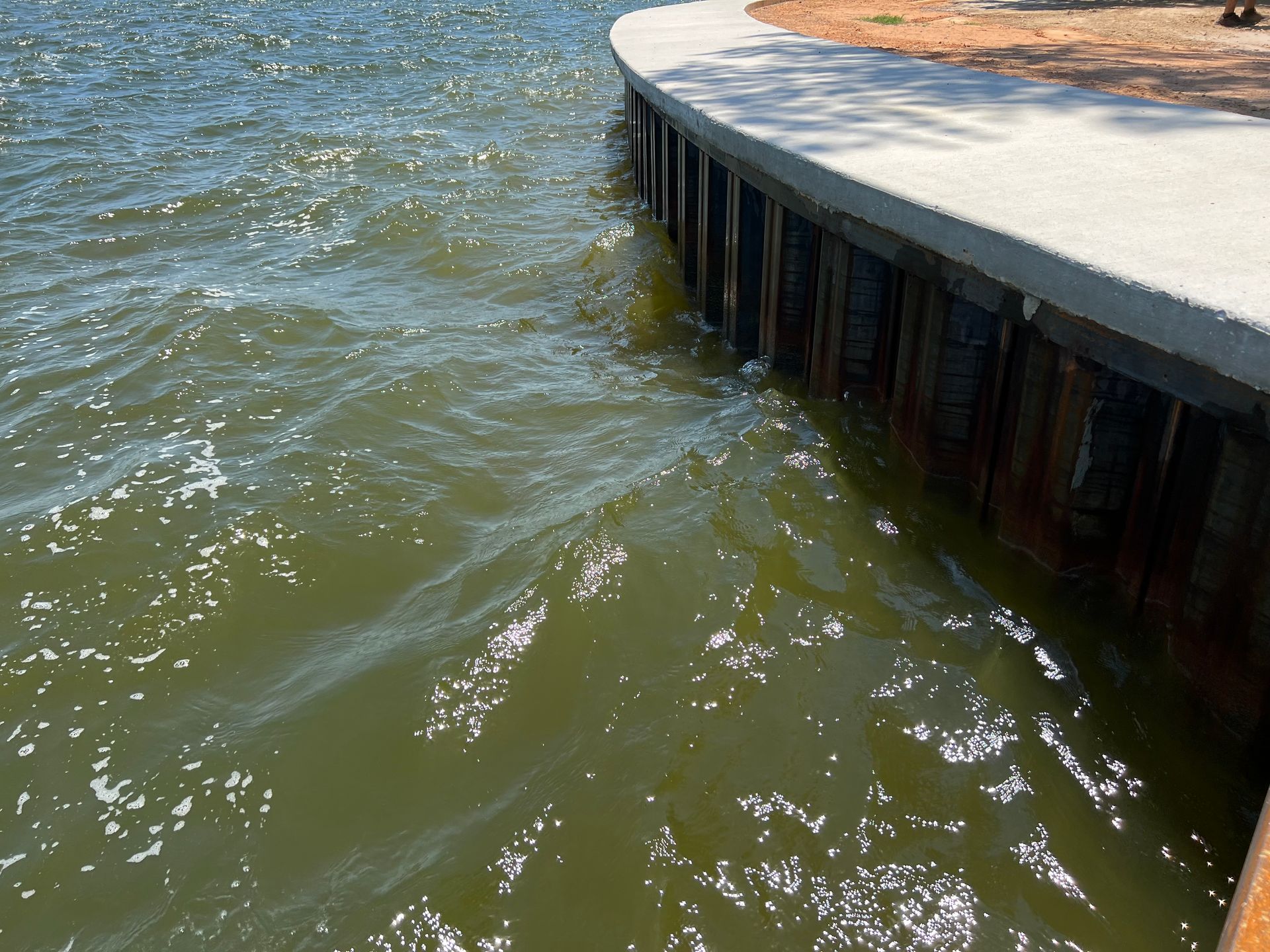 A large body of water is surrounded by a concrete wall.