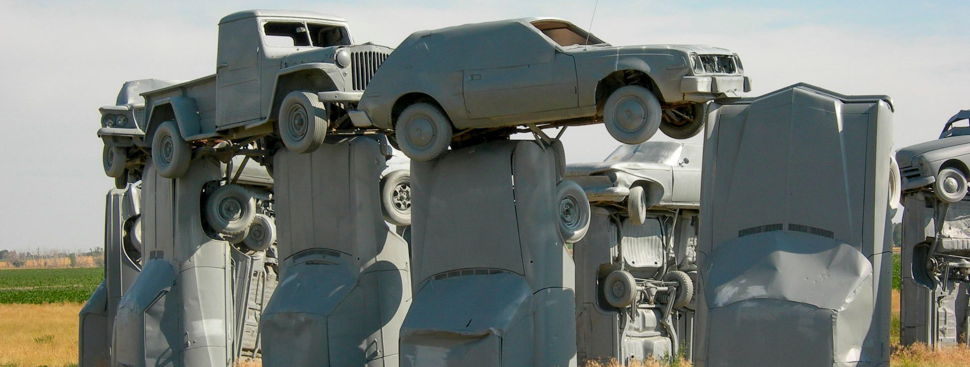 Carhenge, a replica of Stonehenge made from gray-painted vintage automobiles arranged in a circle in a grassy field.
