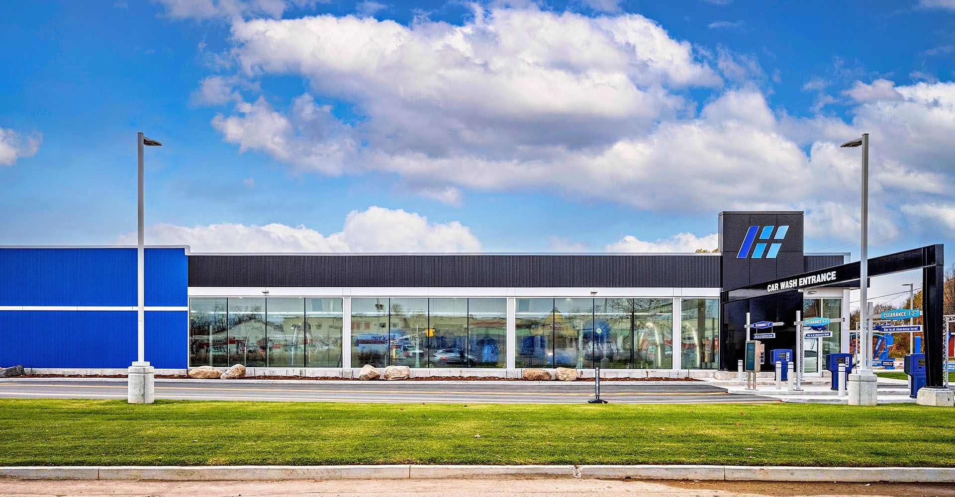 A large building with a lot of windows is sitting on top of a lush green field.