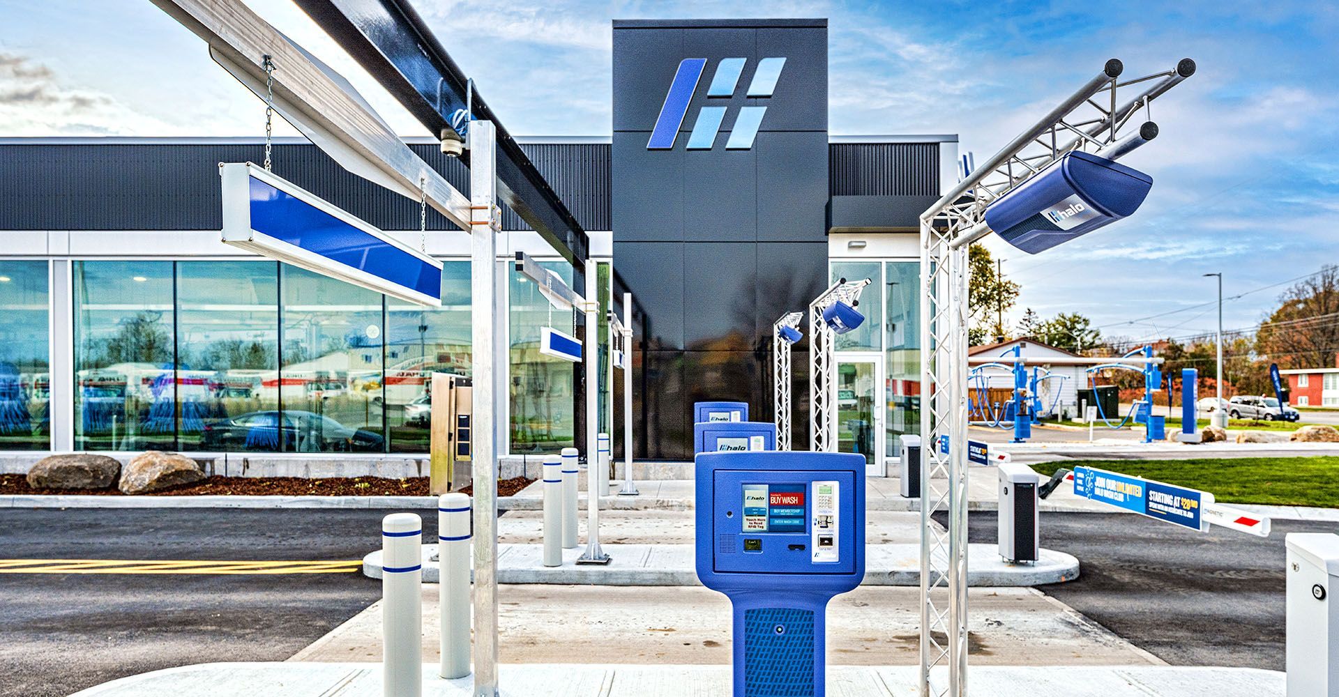 A car wash with a blue machine in front of a building.
