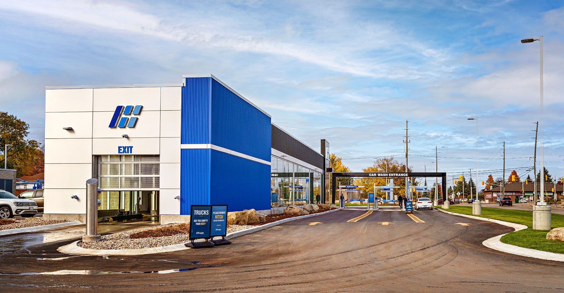 A blue and white building with a lot of cars parked in front of it.