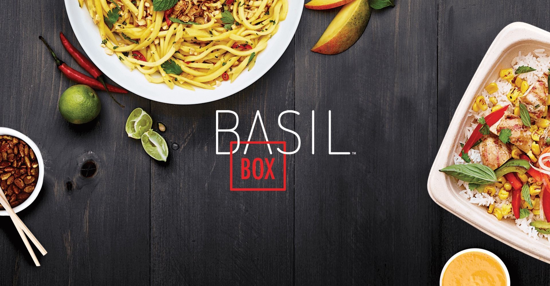 A bowl of spaghetti and a bowl of rice are on a wooden table.