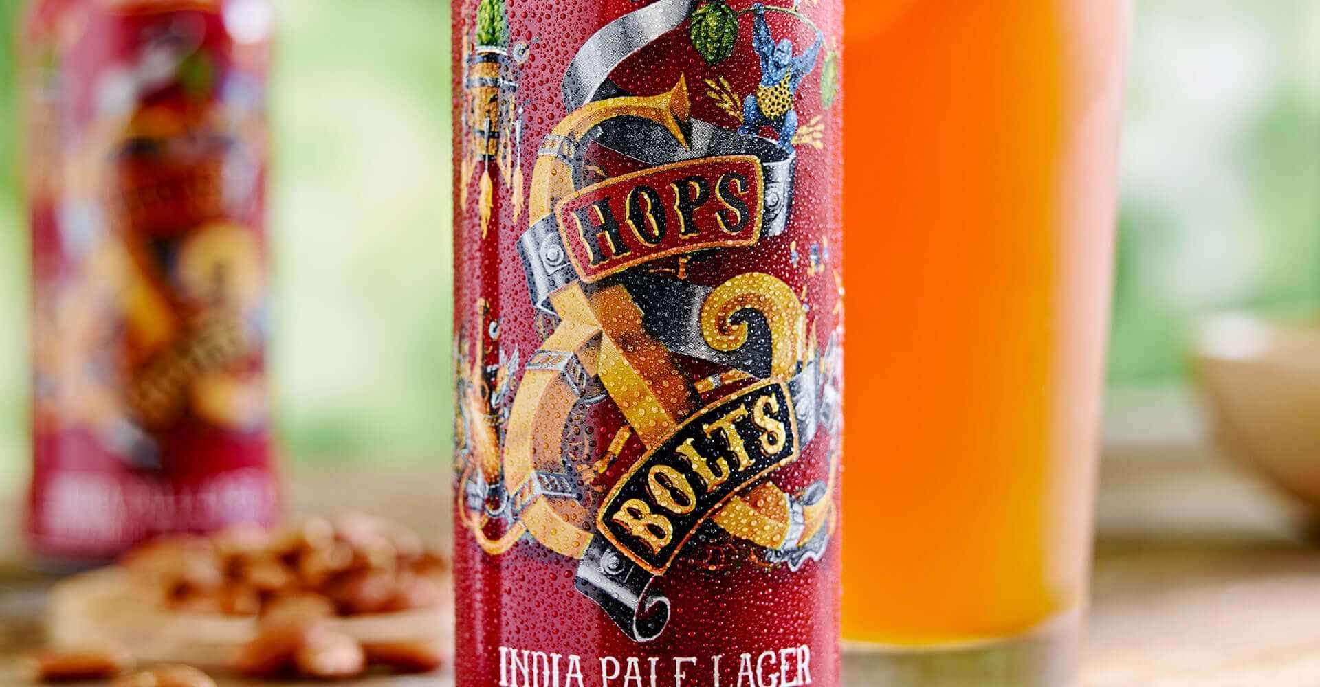 A can of beer is sitting on a table next to a glass of beer.