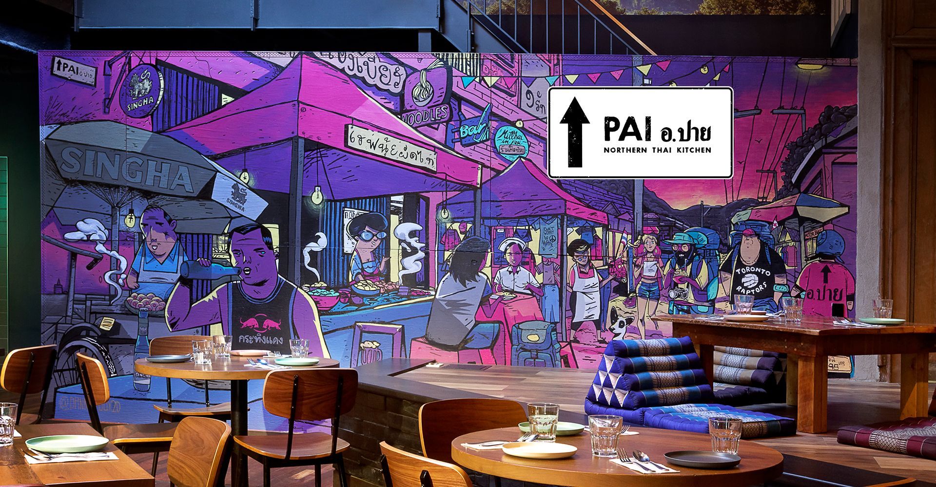 A restaurant with tables and chairs and a mural on the wall.