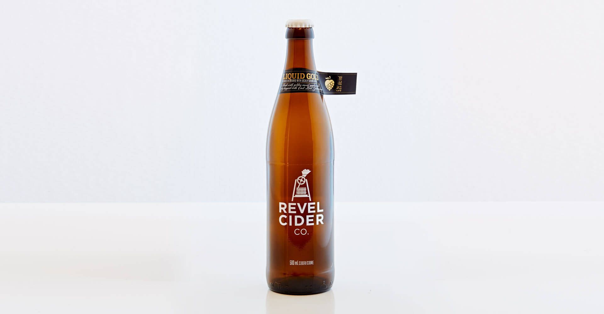 A bottle of revel cider is sitting on a table.