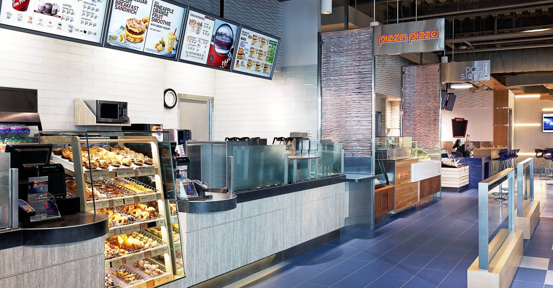A restaurant with a counter and a display case of food