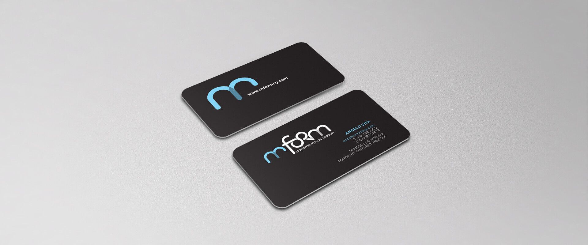Two black business cards are sitting on a white surface.