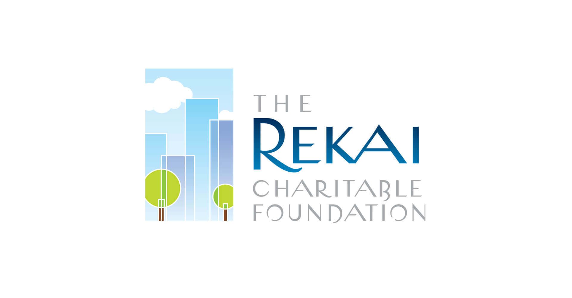 A logo for the rekai charitable foundation with a city skyline and trees.