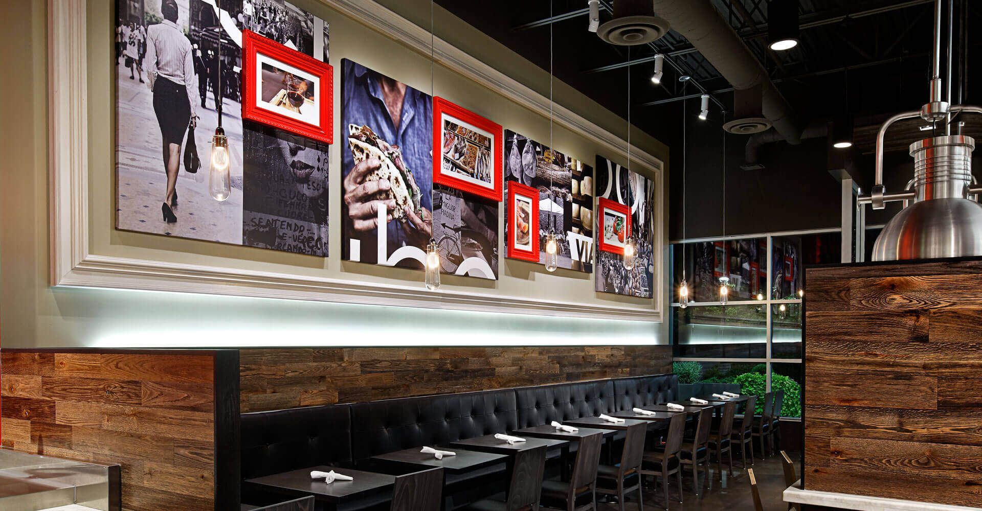 A restaurant with tables and chairs and pictures on the wall