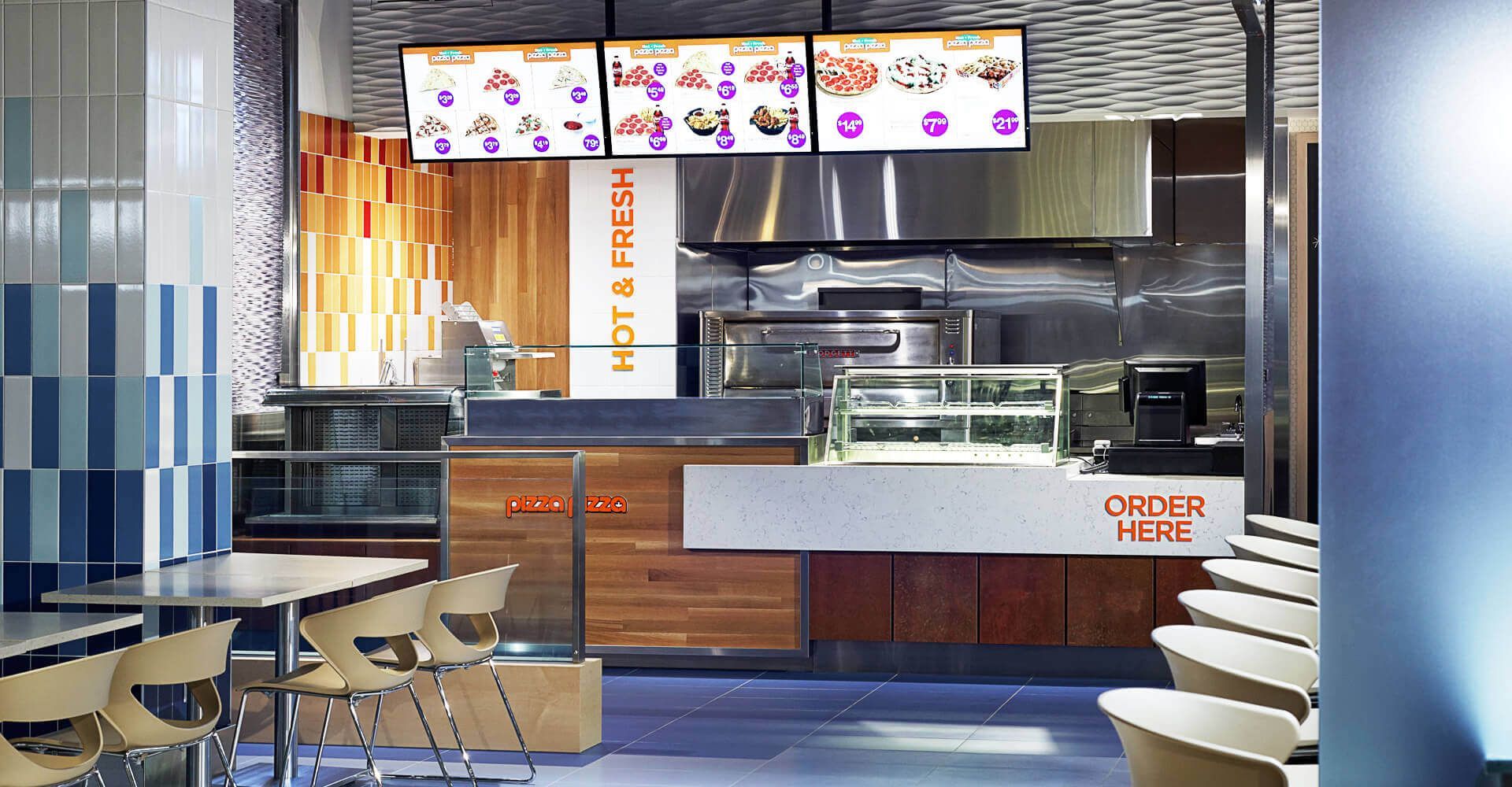 A restaurant with tables and chairs and a sign that says order here
