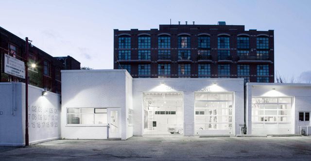 A white building with a brick building in the background