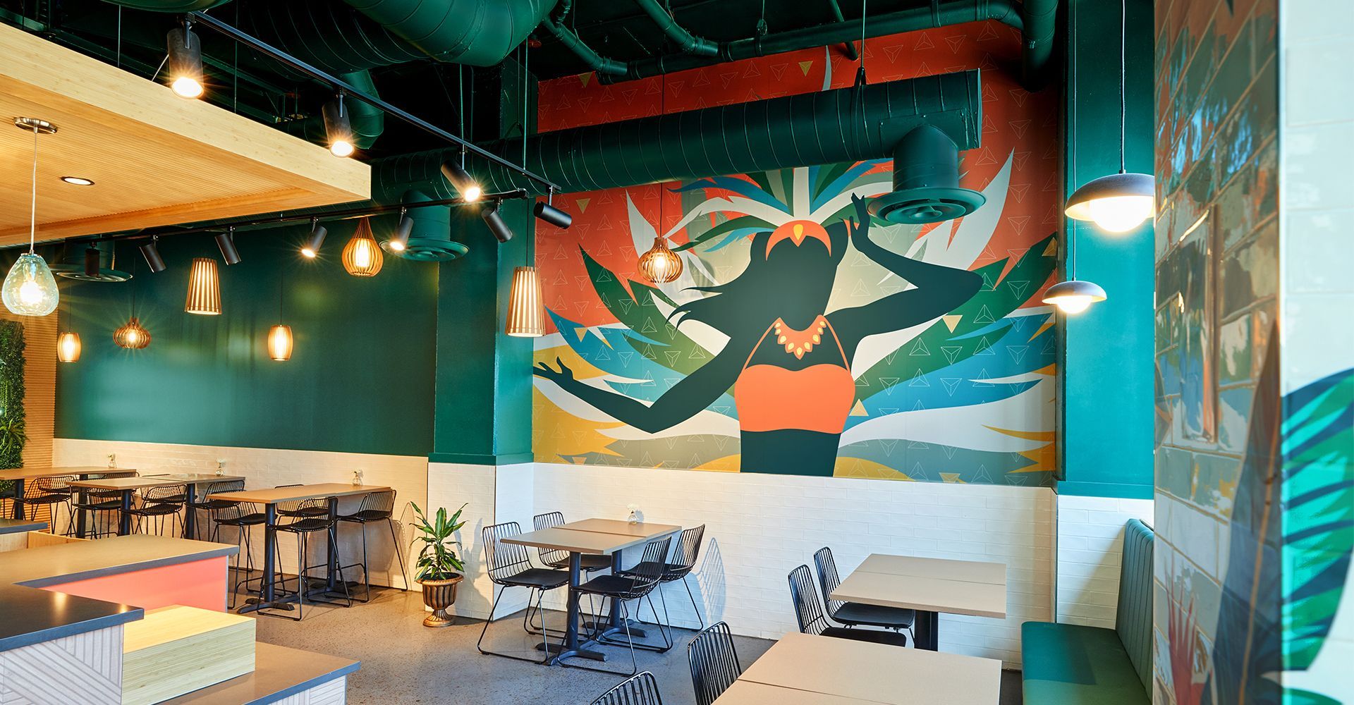 A restaurant with tables and chairs and a mural on the wall.