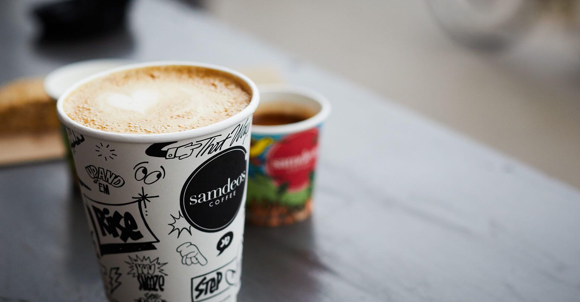 Two cups of coffee are sitting on a table.
