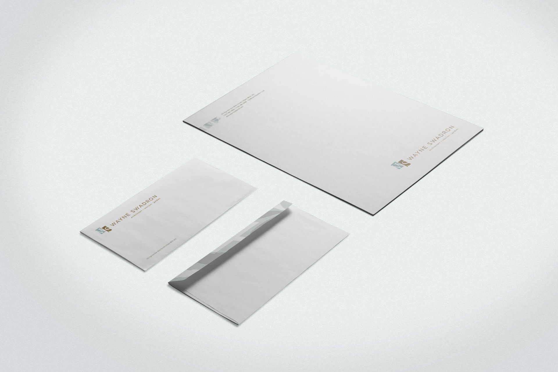 A mockup of a letterhead and envelopes on a white surface
