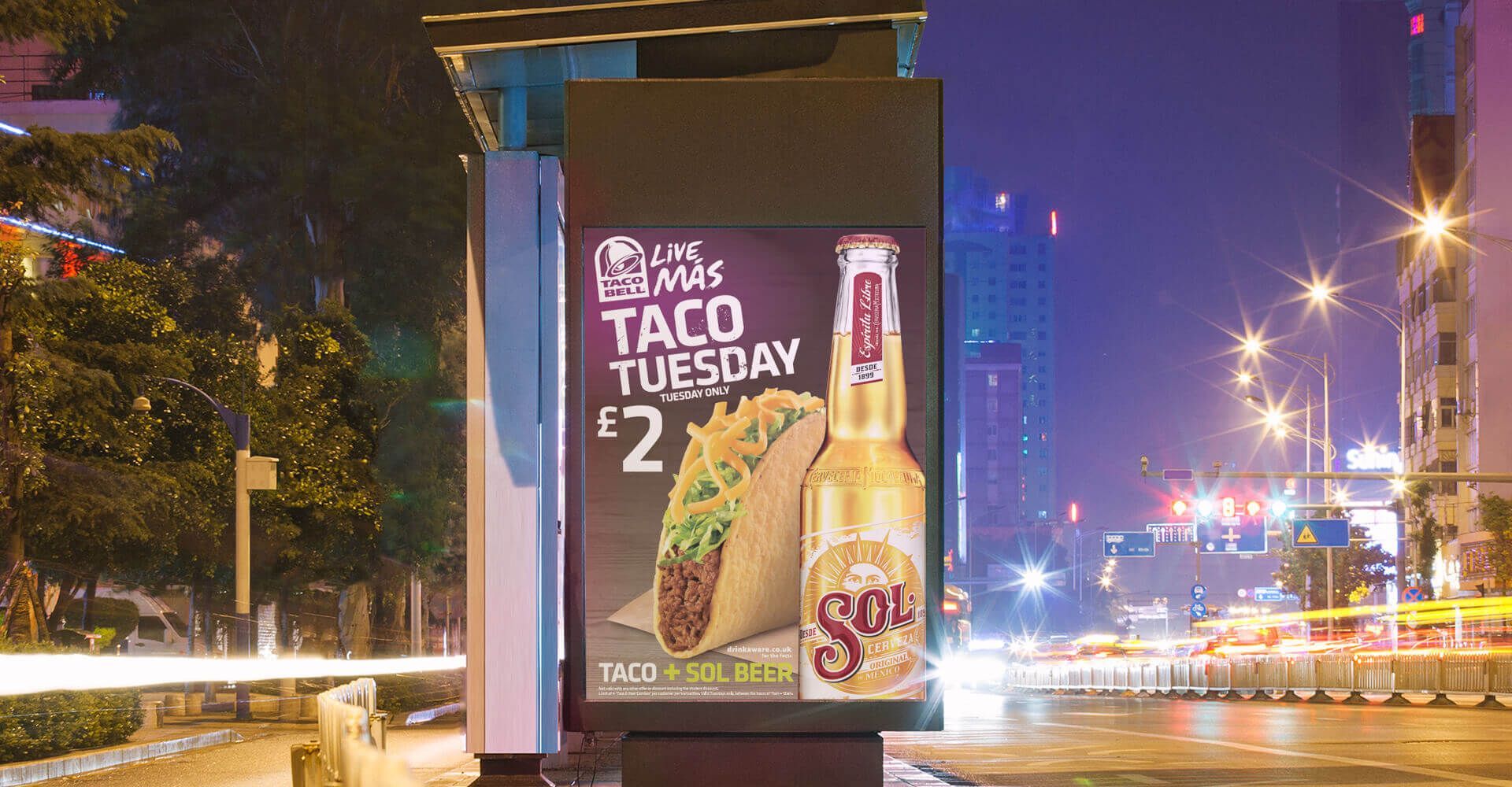 A billboard with a taco and a bottle of beer on it.