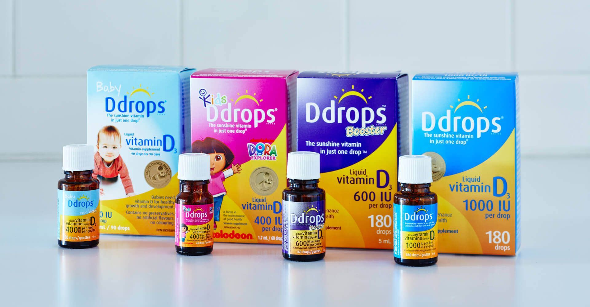 A group of bottles and boxes of ddrops are sitting on a table.