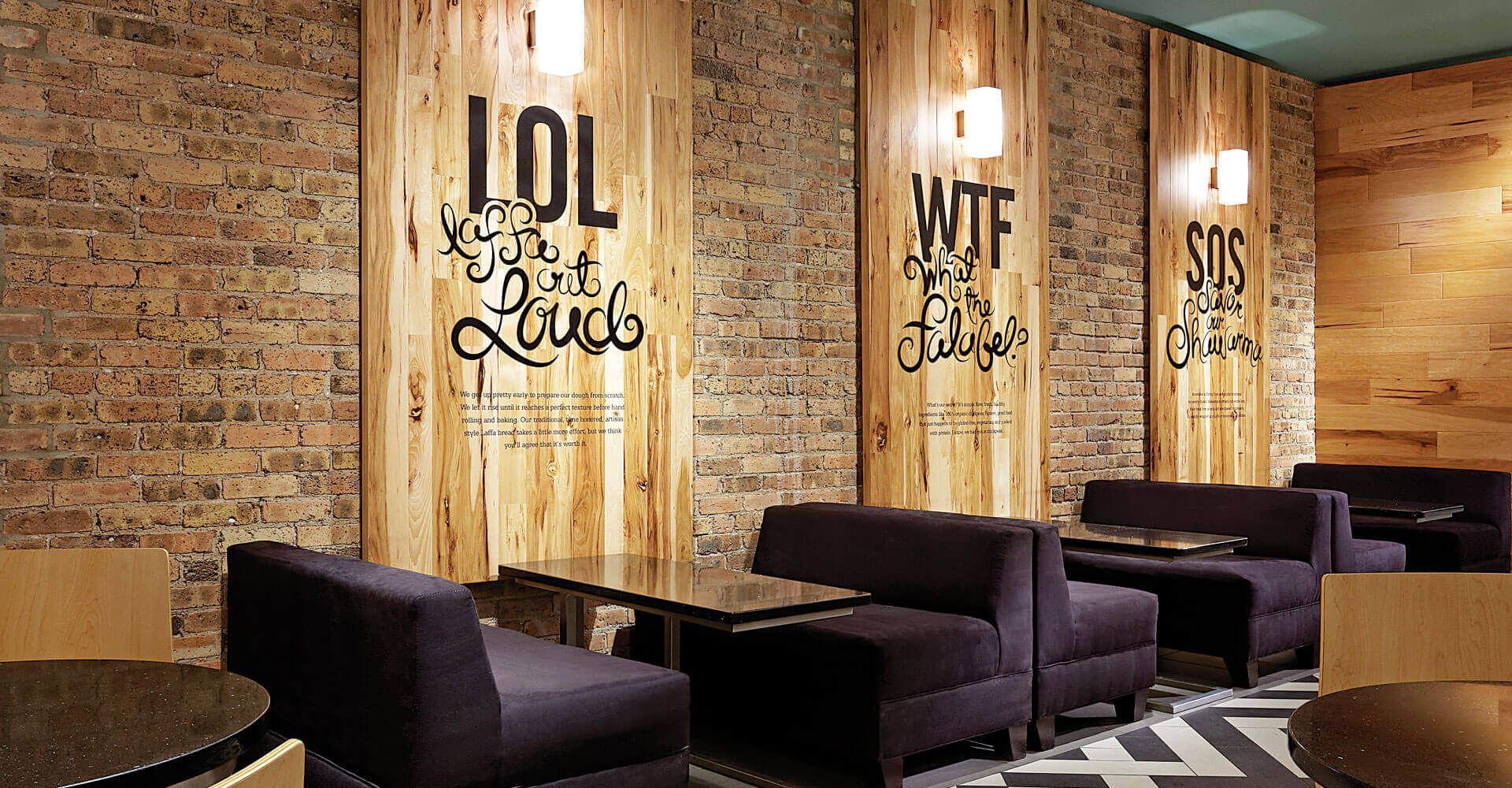 A restaurant with a brick wall and wooden tables and chairs