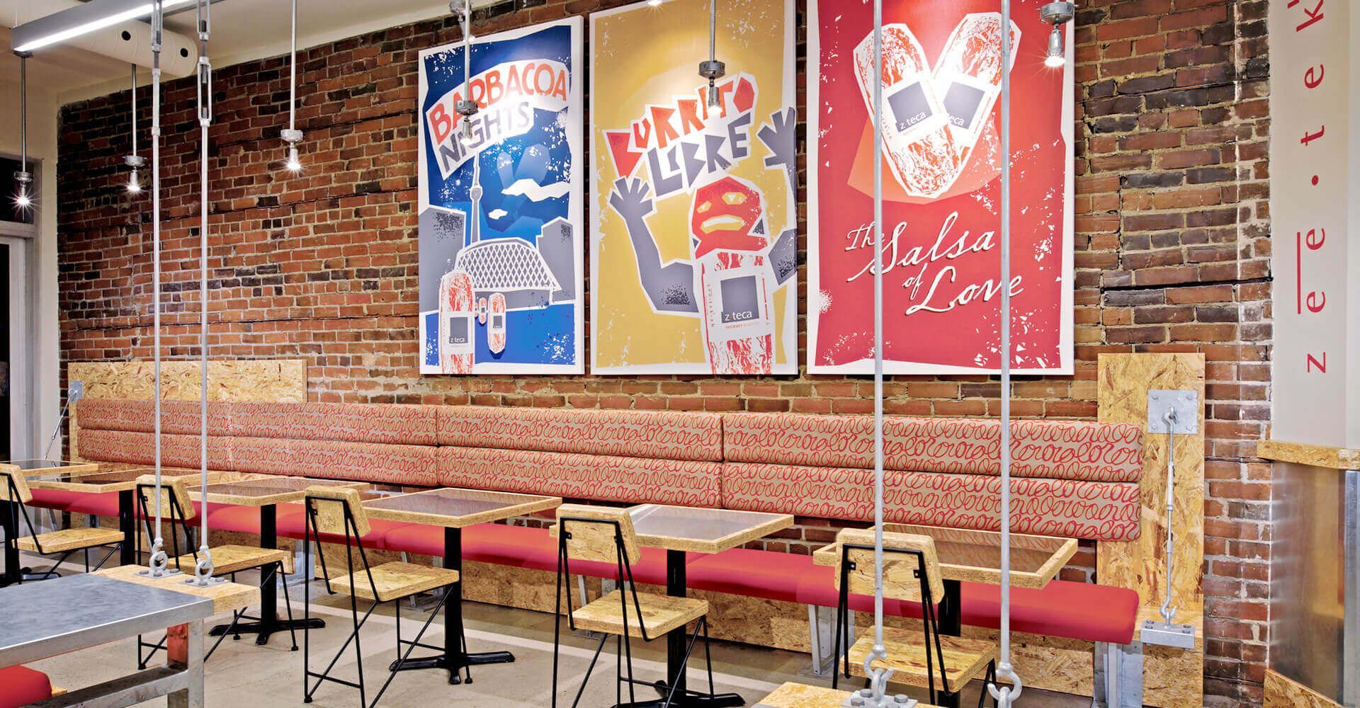 A restaurant with tables and chairs and posters on the wall.