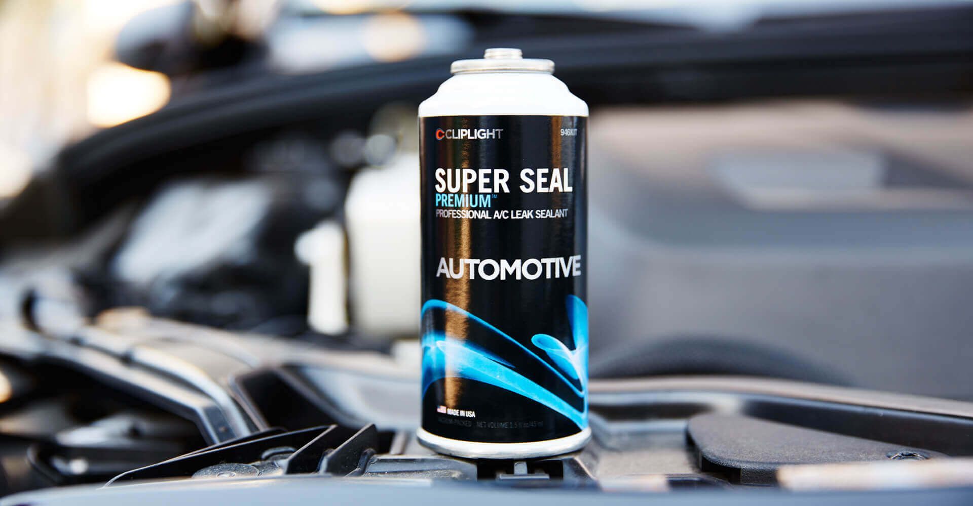 A can of super seal automotive is sitting on the hood of a car.