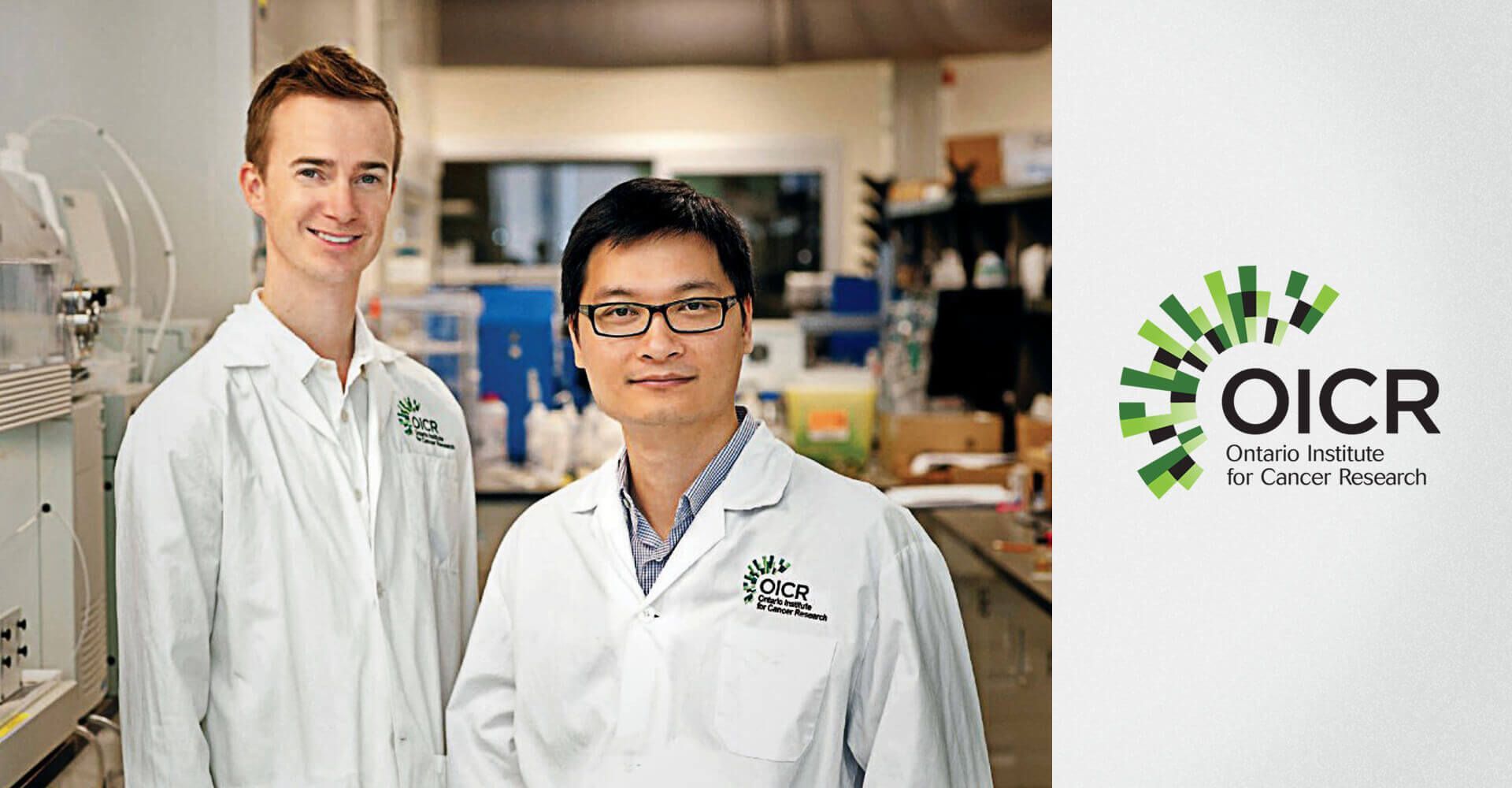 Two men in lab coats are standing next to each other in a lab.