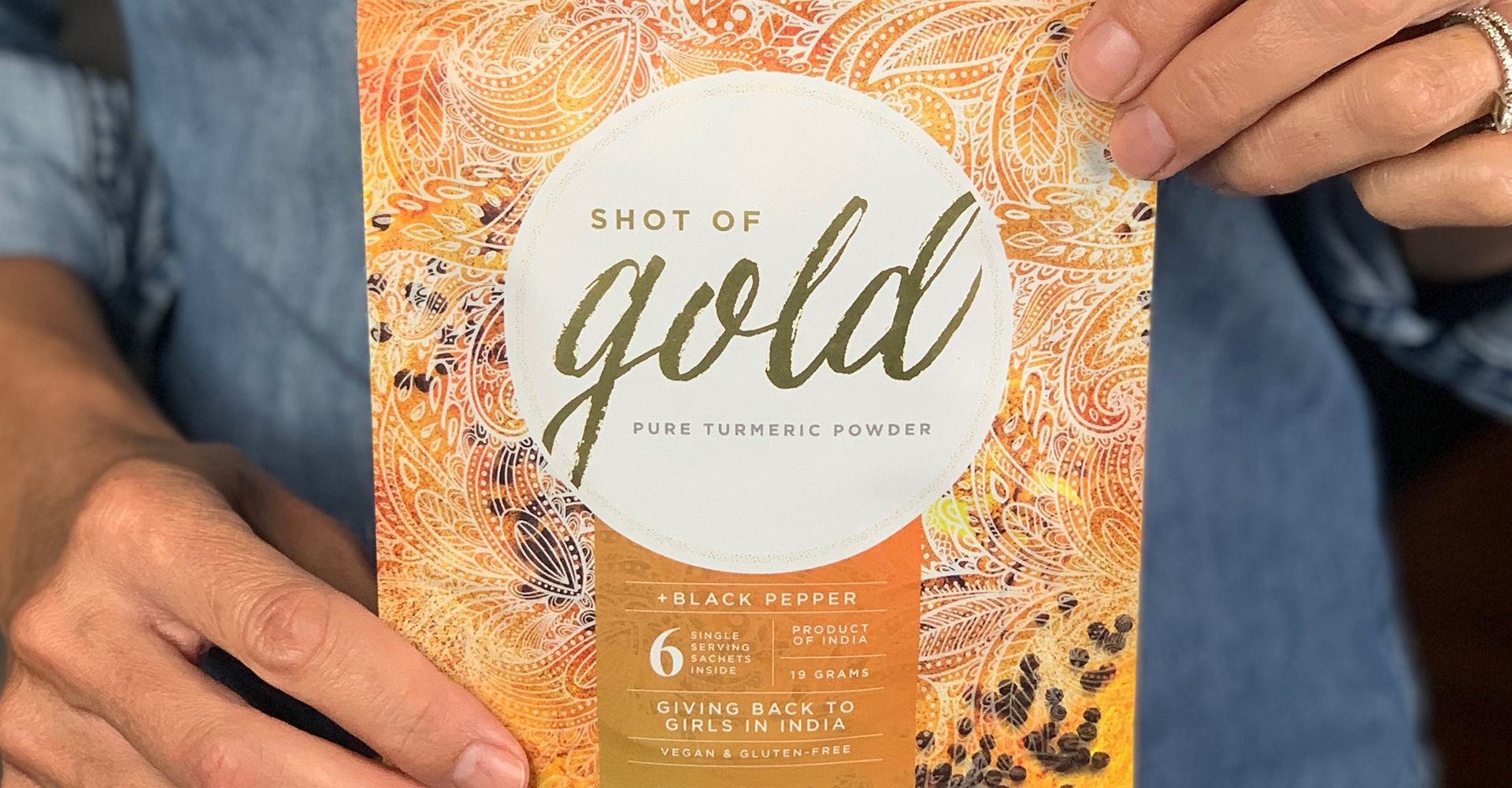 A person is holding a book called gold in their hands.