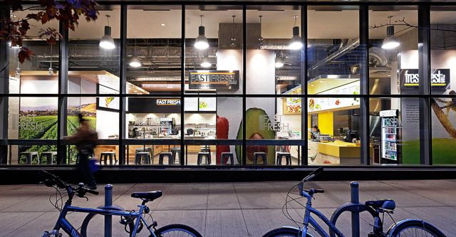 Two bicycles are parked in front of a store.