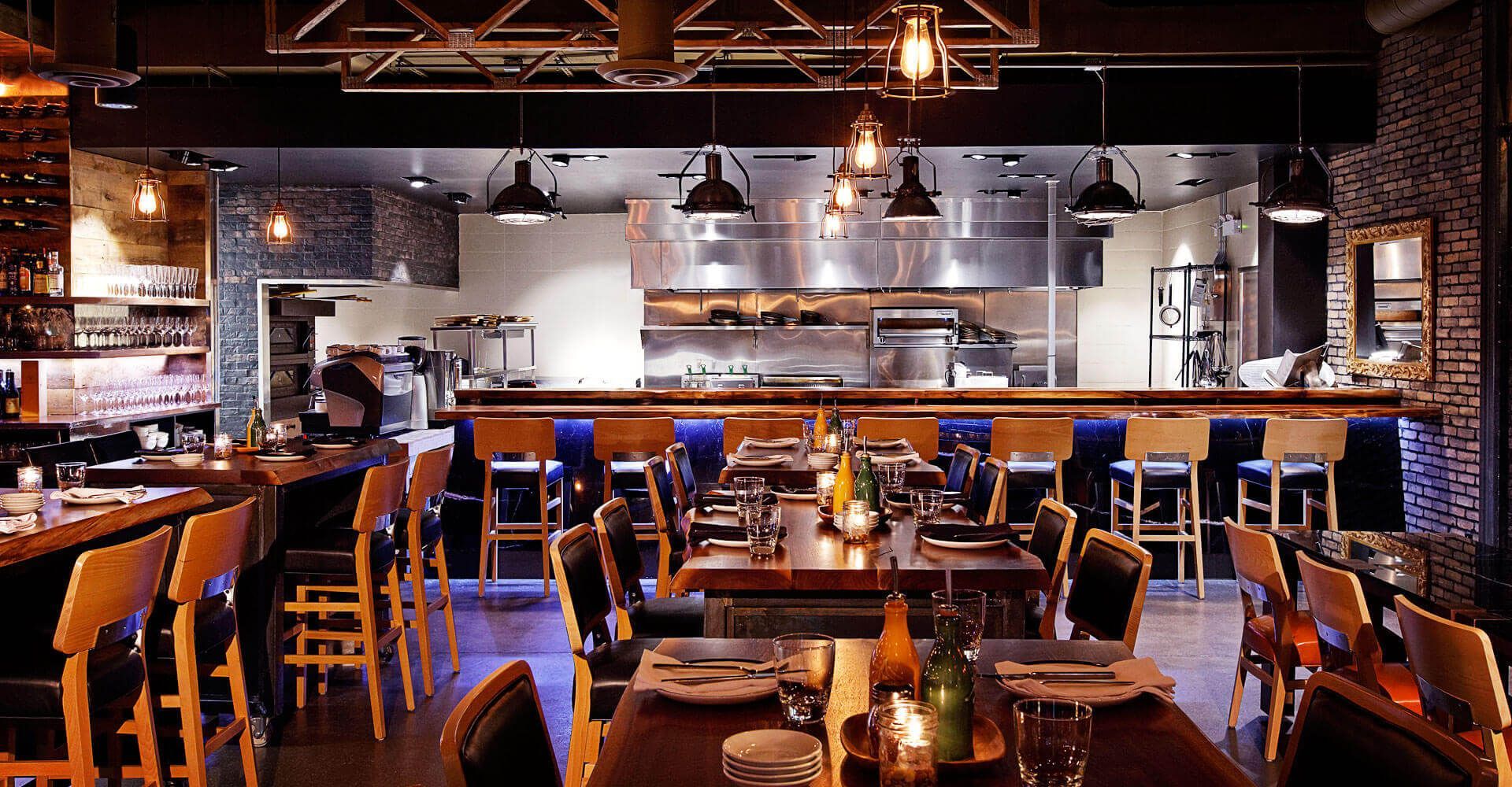 A restaurant with tables and chairs and a kitchen in the background