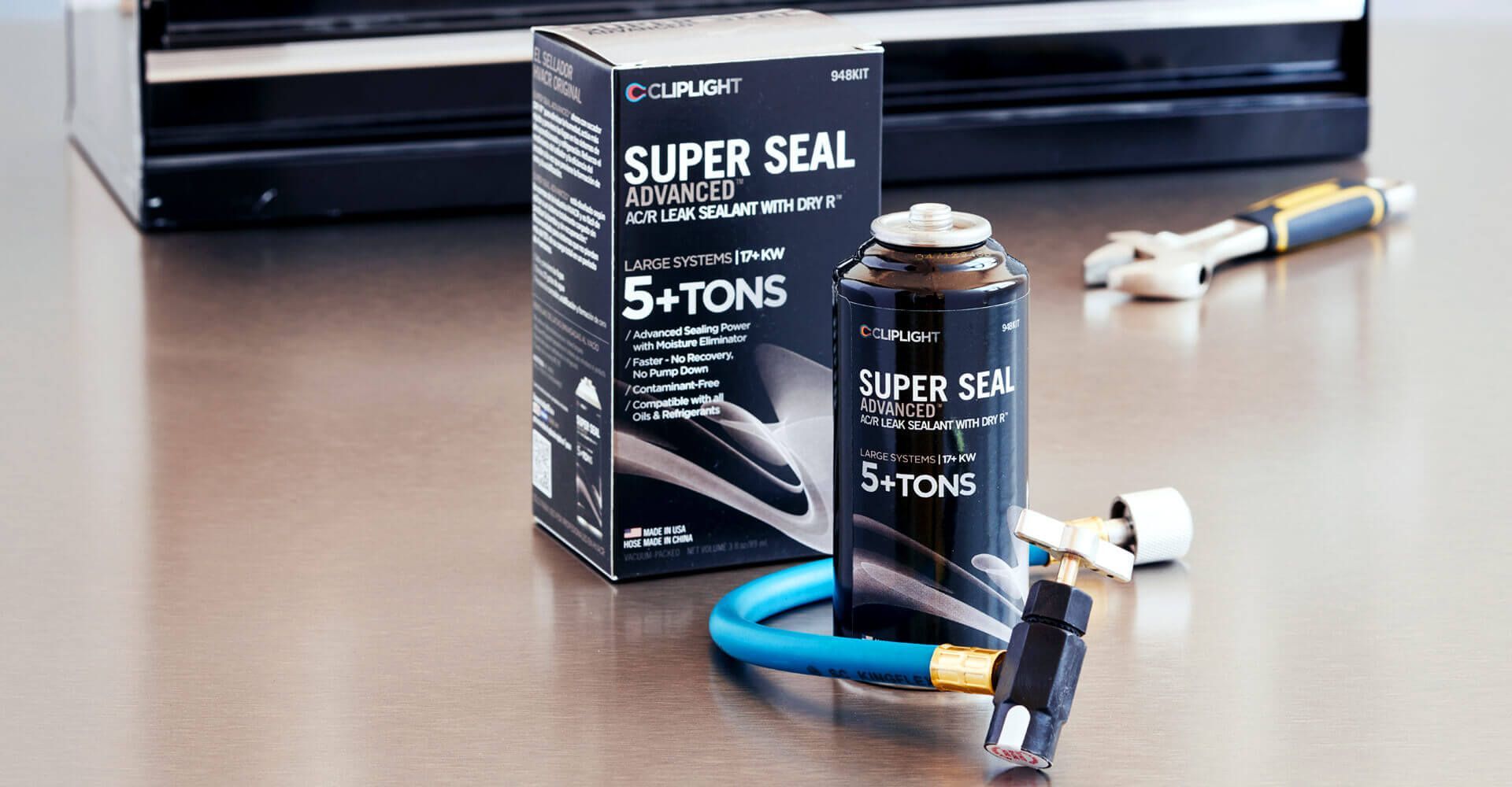 A bottle of super seal 5 + tons is sitting on a table next to a box.