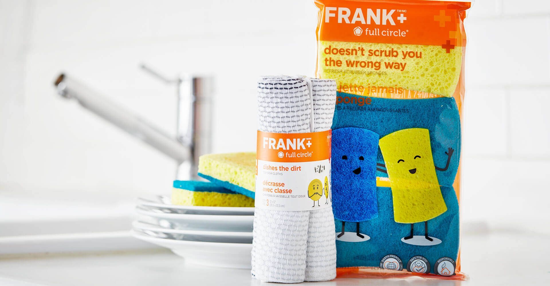 A bag of frank sponges is sitting on a counter next to a stack of plates.