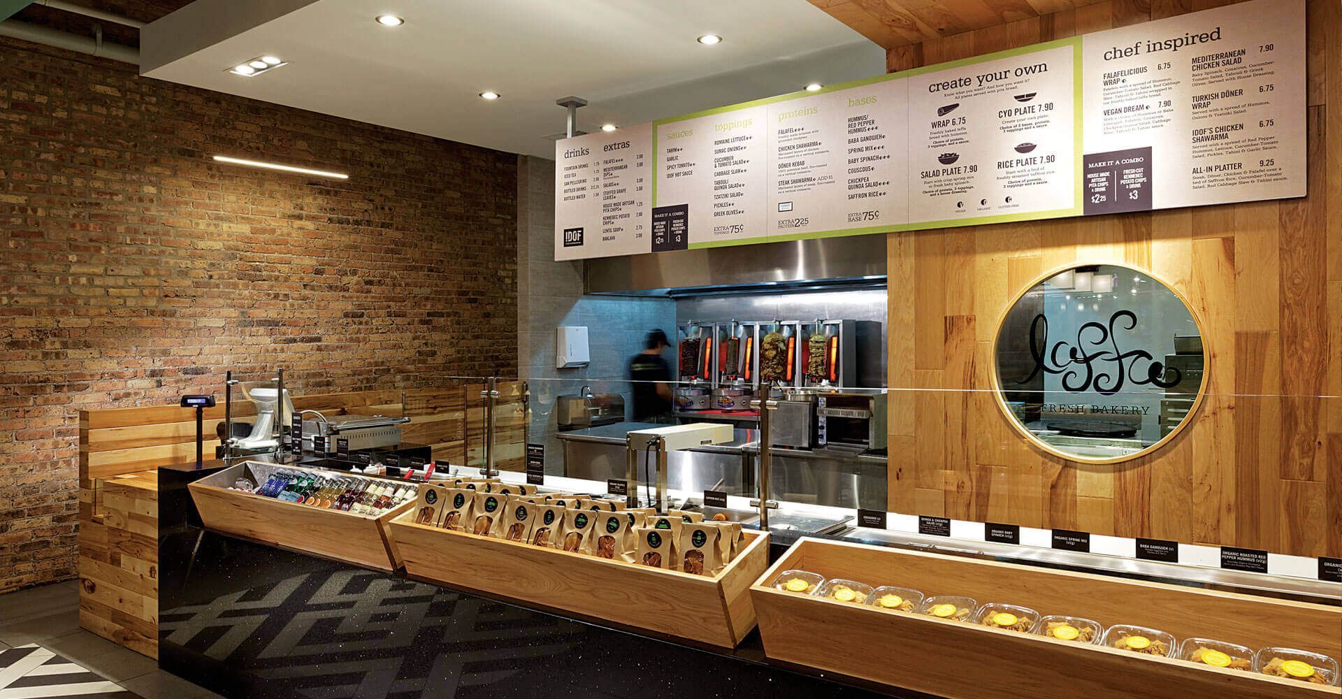 A restaurant with a wooden counter and a brick wall.