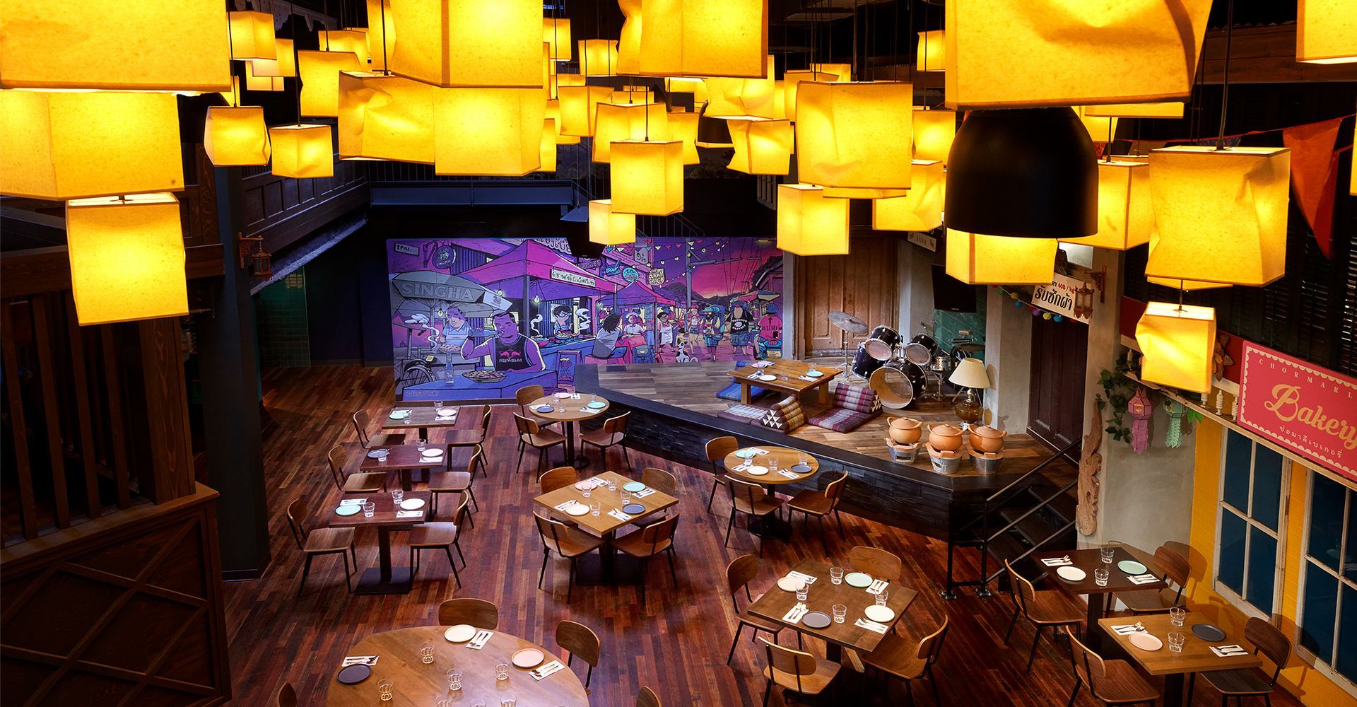 An aerial view of a restaurant with tables and chairs and a stage.