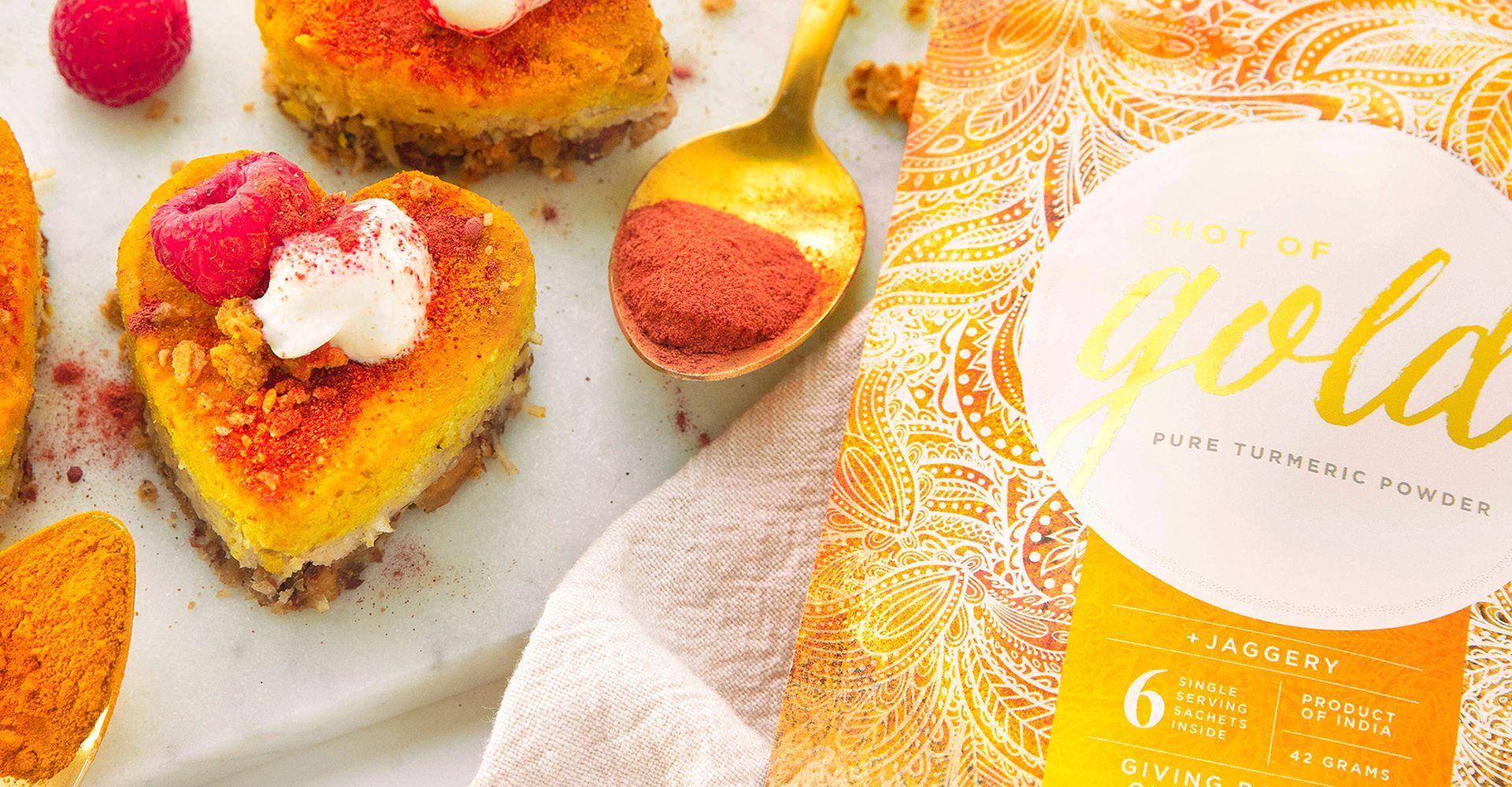 A white plate topped with heart shaped desserts next to a bag of gold powder.