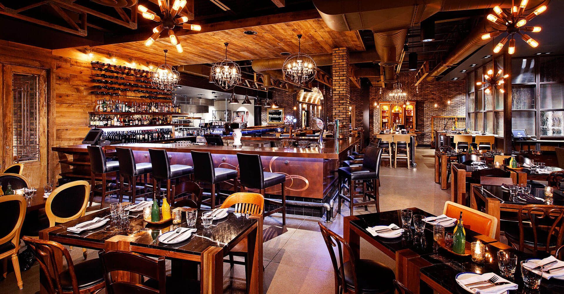 A restaurant filled with tables and chairs and a bar.