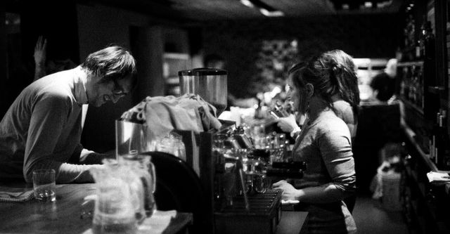 A man and a woman are sitting at a bar.