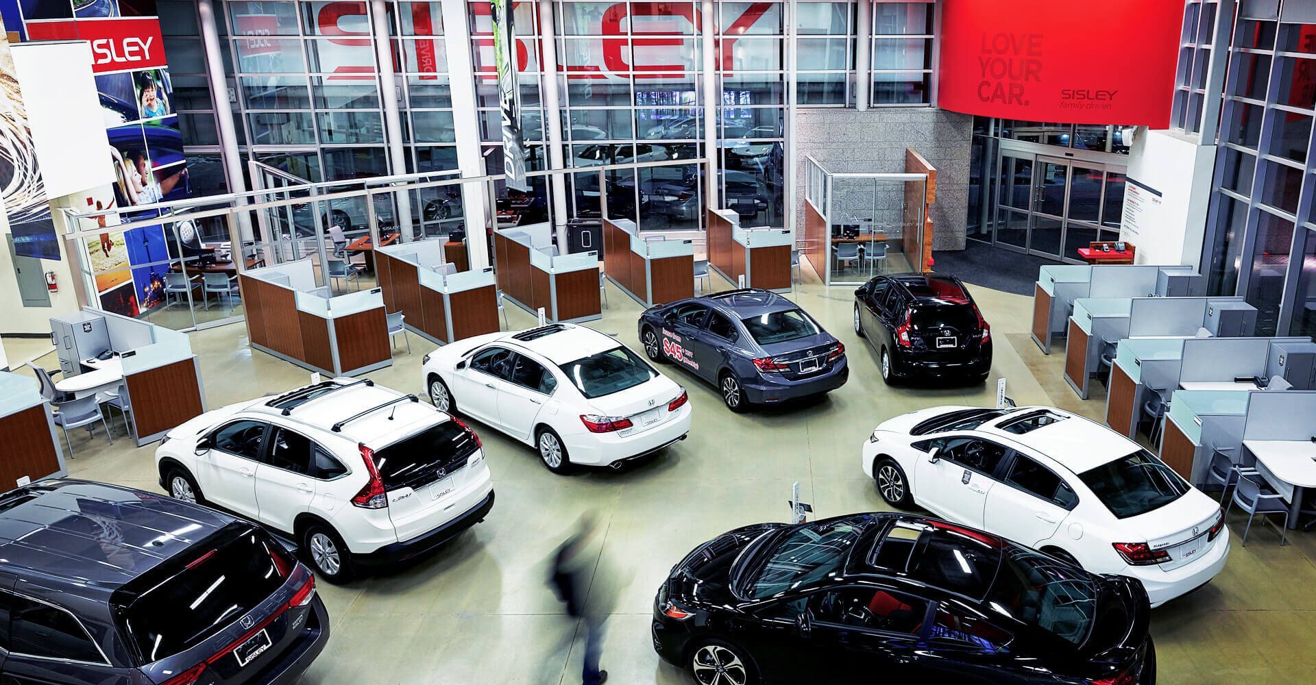 A group of cars are lined up in a showroom.