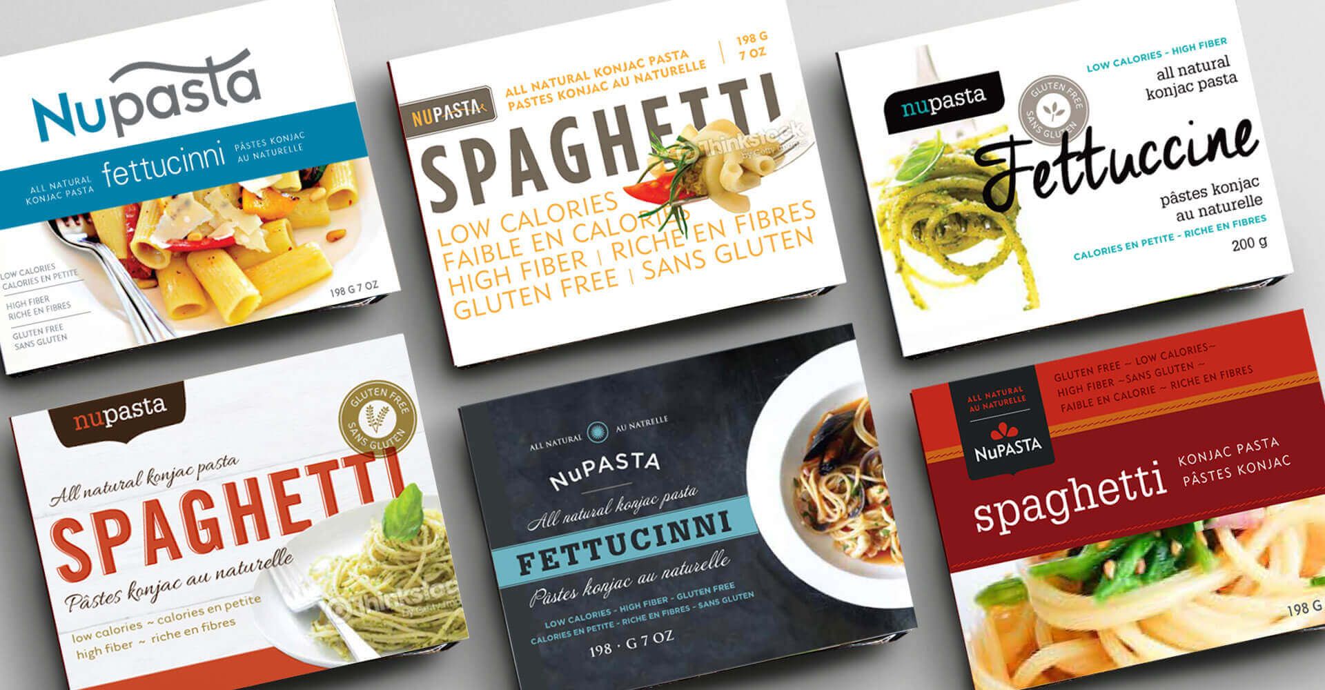 A variety of packages of spaghetti and fettuccini are displayed on a table.