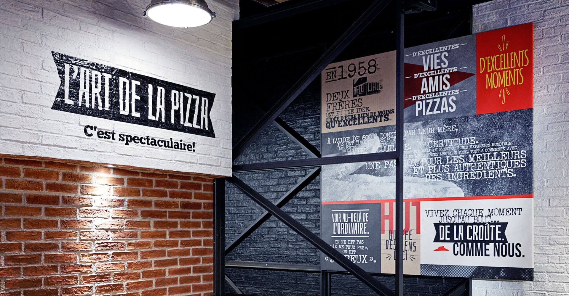 A brick wall with a sign that says l' art de la pizza