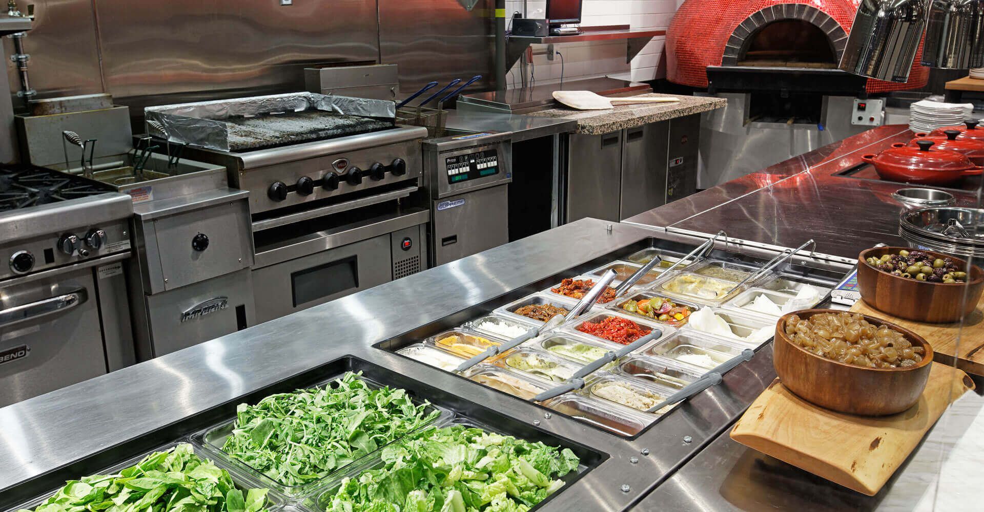 A kitchen filled with lots of food and vegetables.