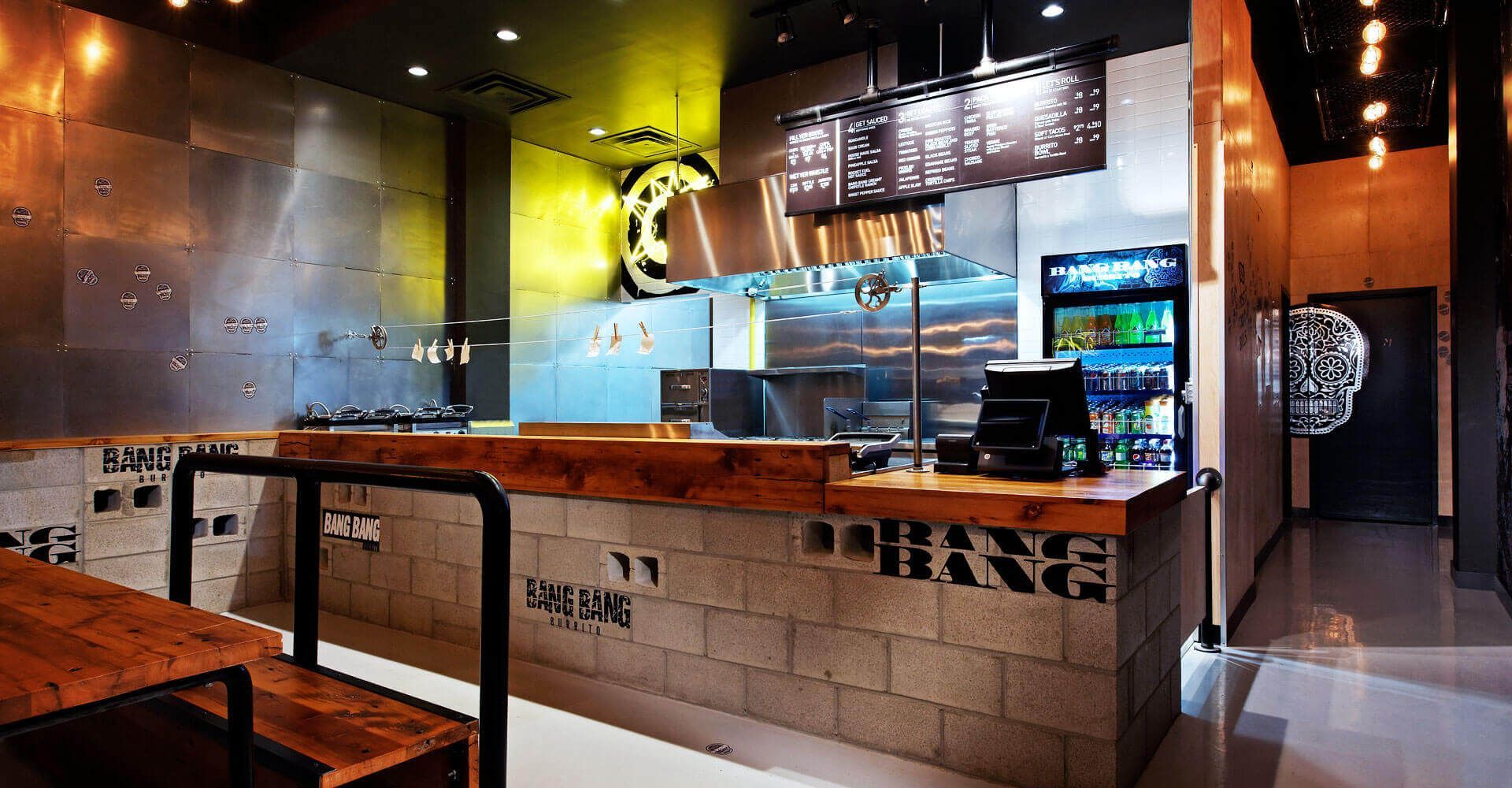 A restaurant with a wooden counter and a refrigerator.