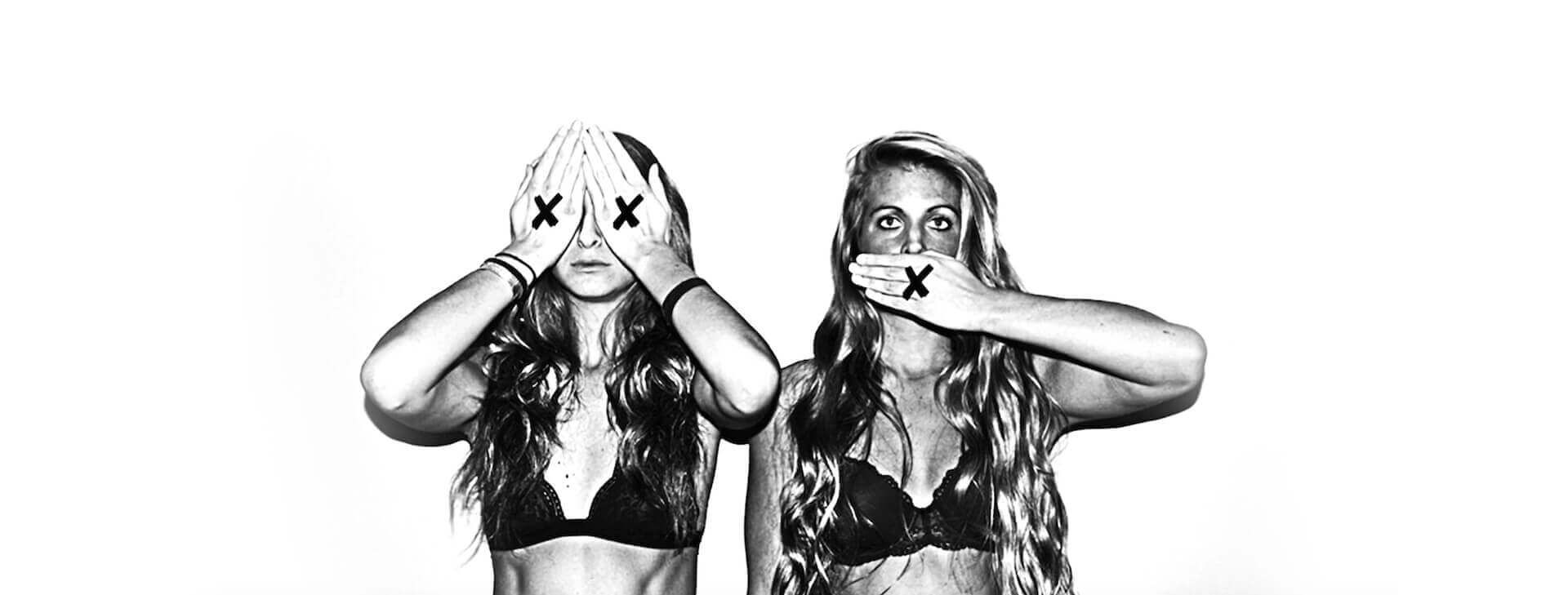 Two women are covering their eyes and mouth with their hands.
