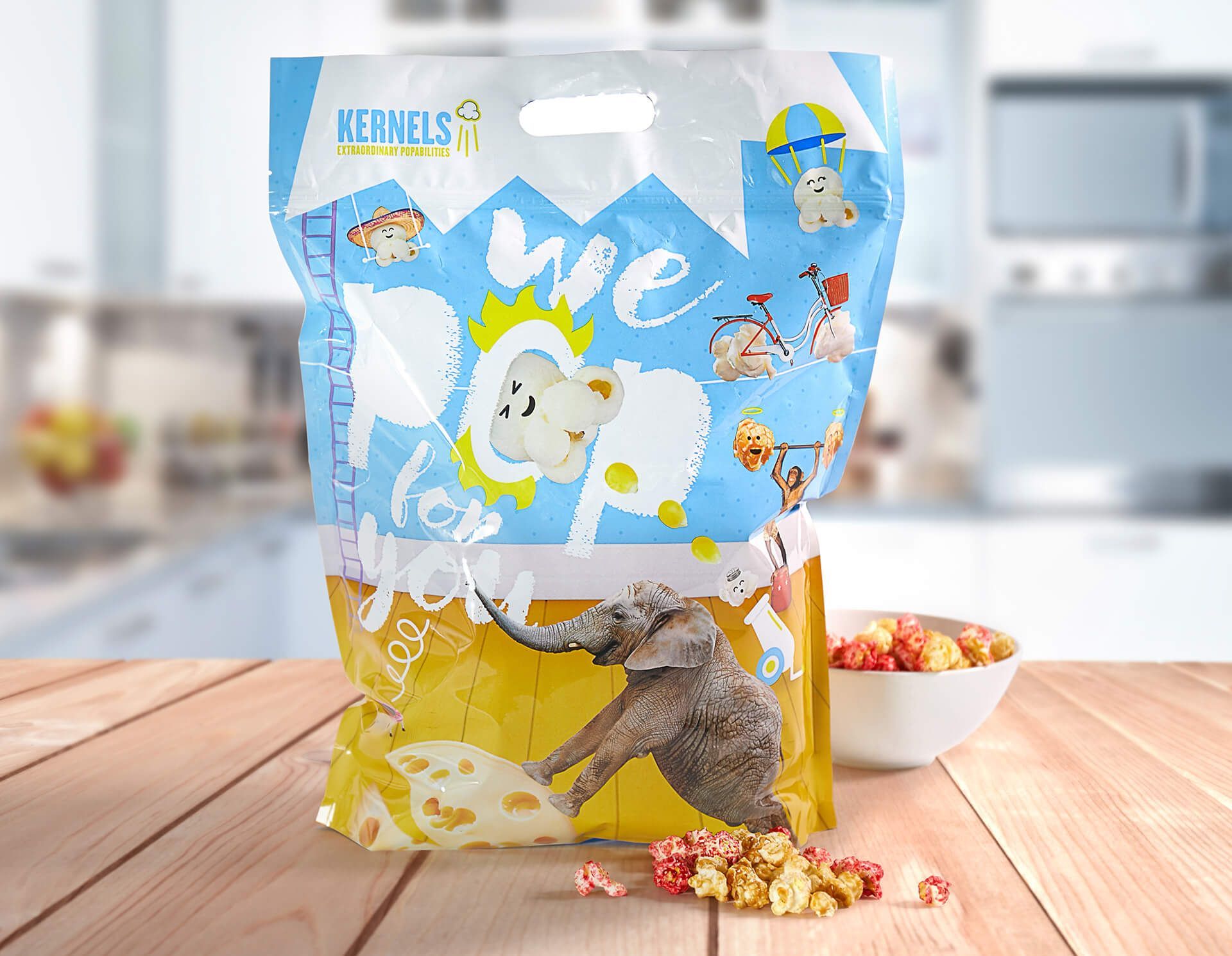 A bag of popcorn is sitting on a wooden table next to a bowl of popcorn.