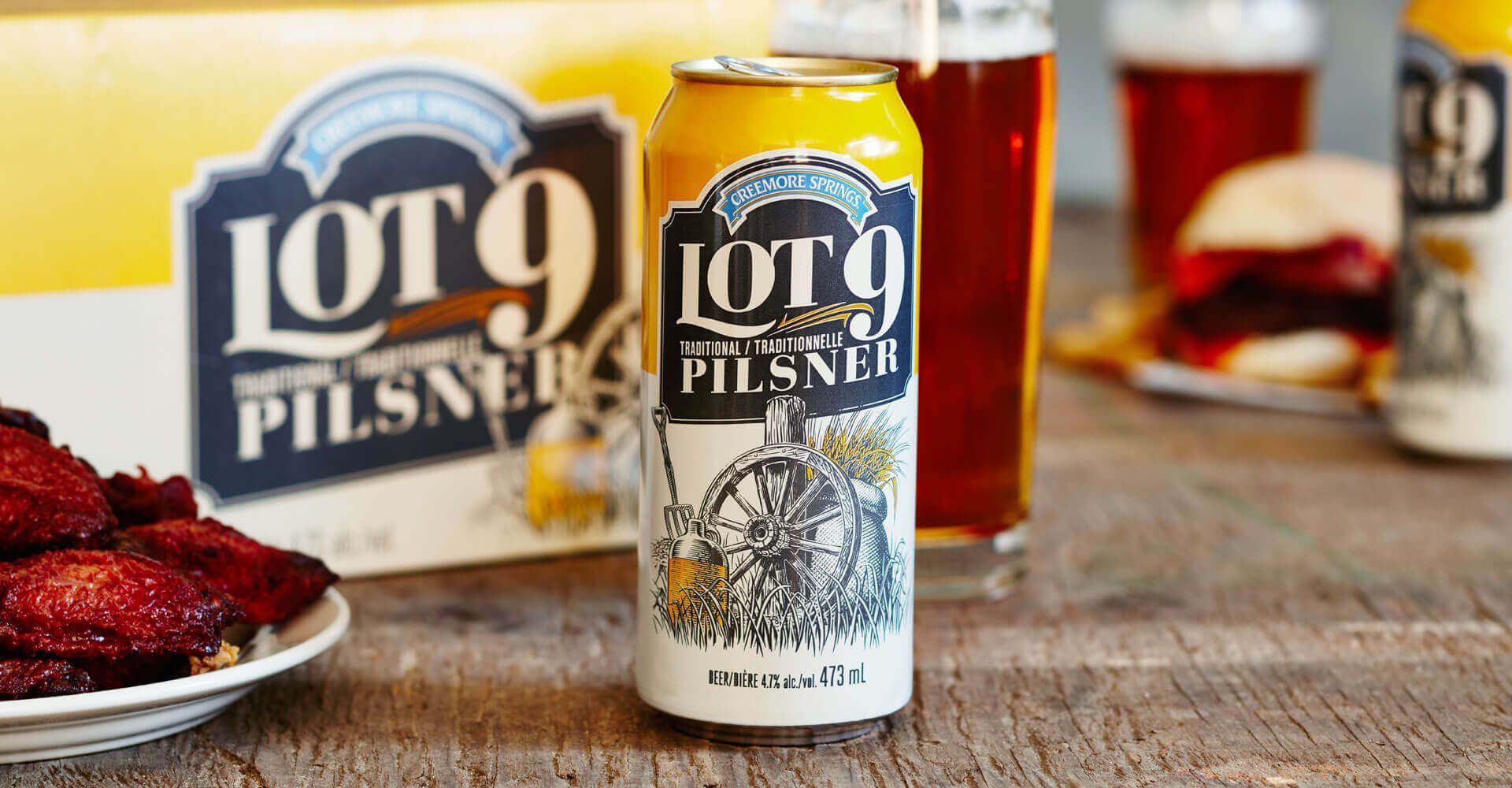 A can of lot 9 pilsner beer is sitting on a wooden table.