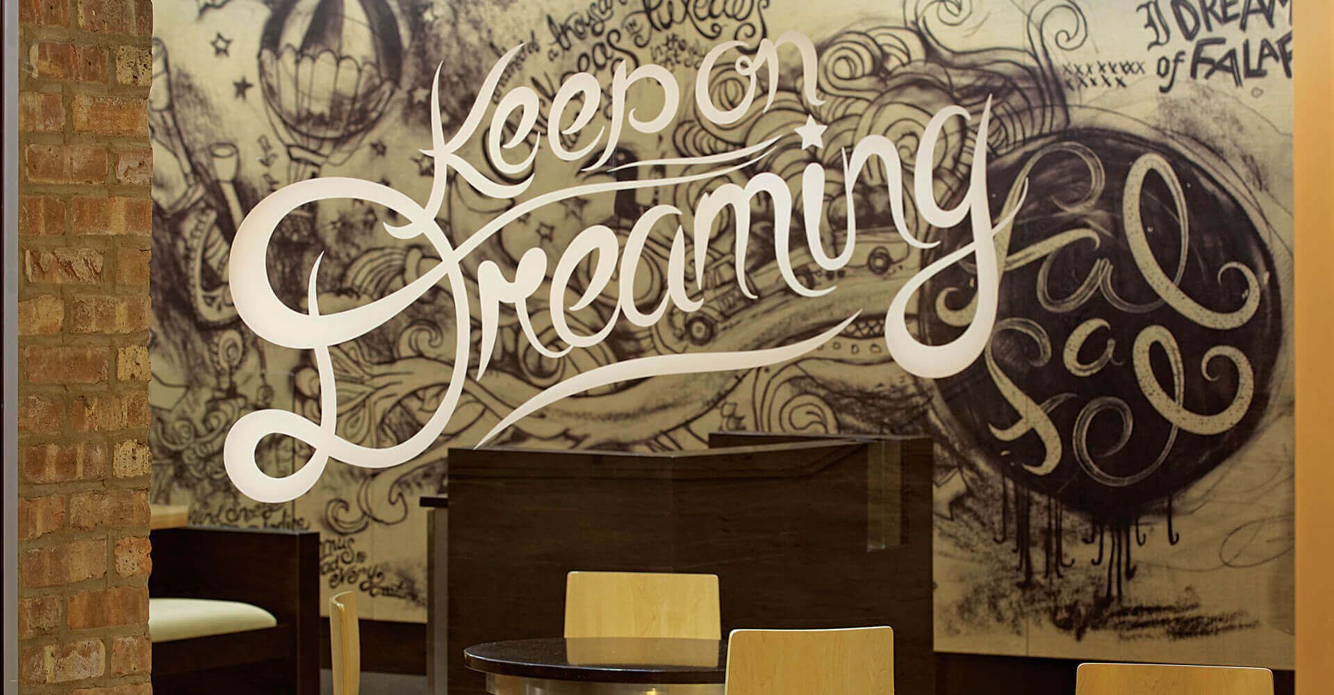 A mural on a wall that says keep on dreaming