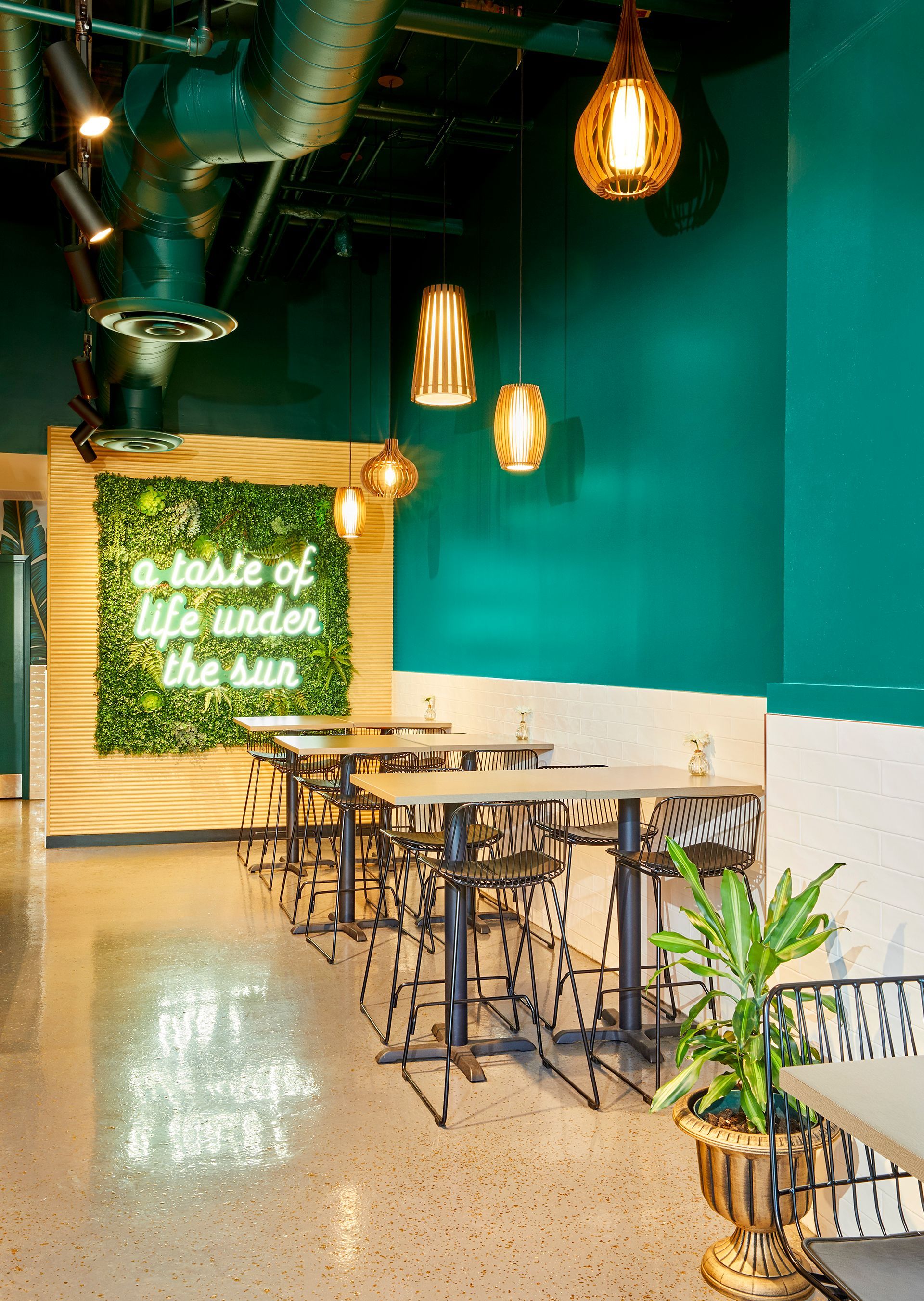 A restaurant with tables and chairs and a sign that says `` a taste of life under the sun ''.