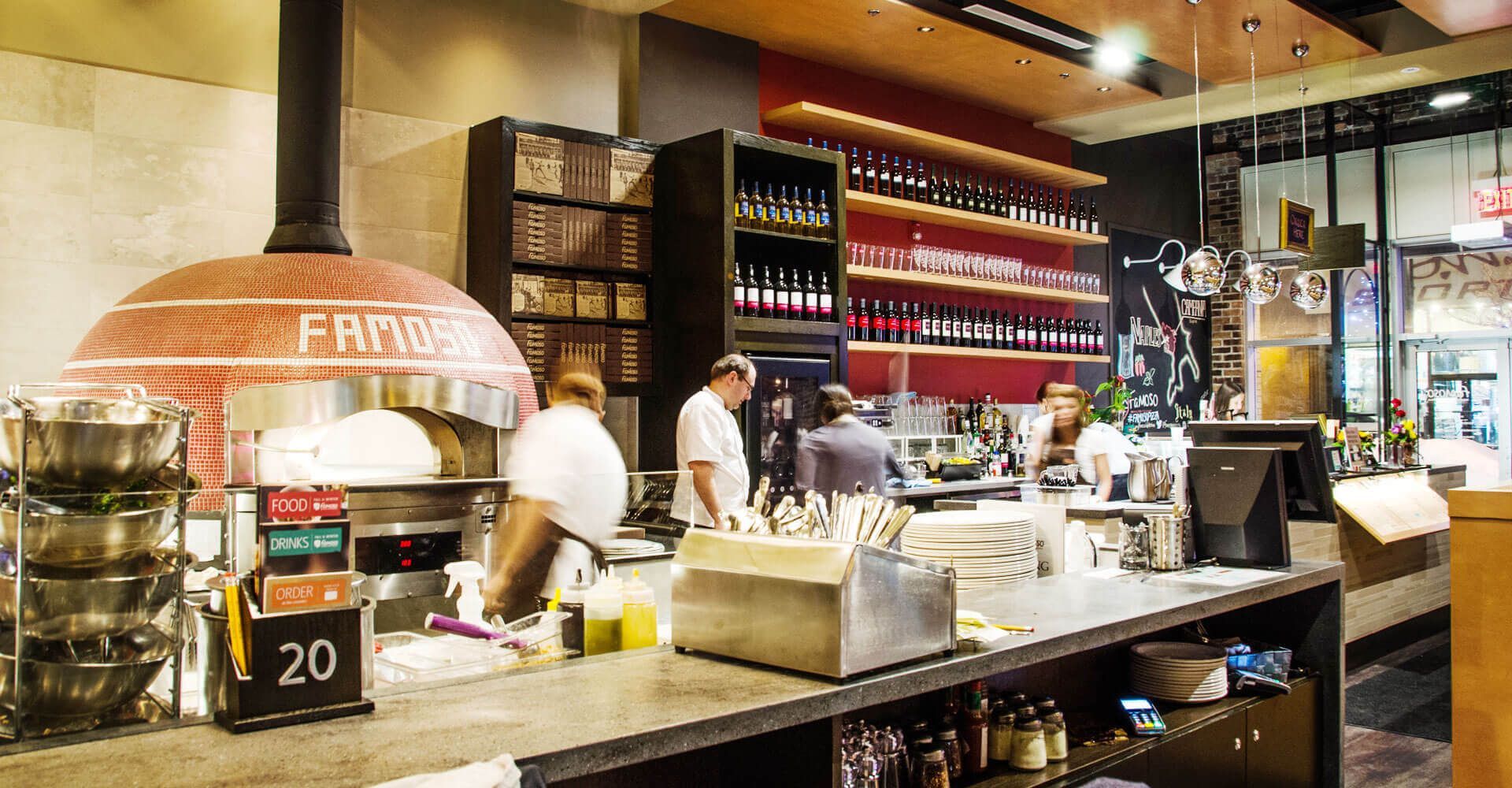 A restaurant with a pizza oven and a bar.