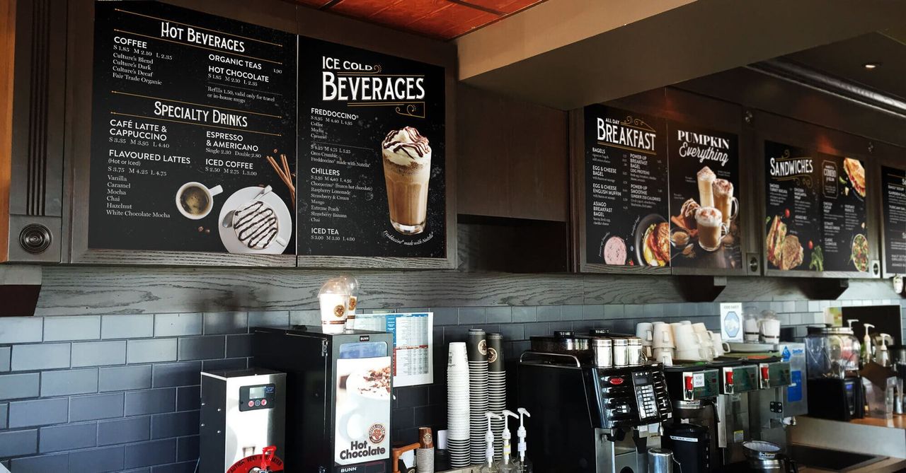A coffee shop with a menu on the wall that says beverages.