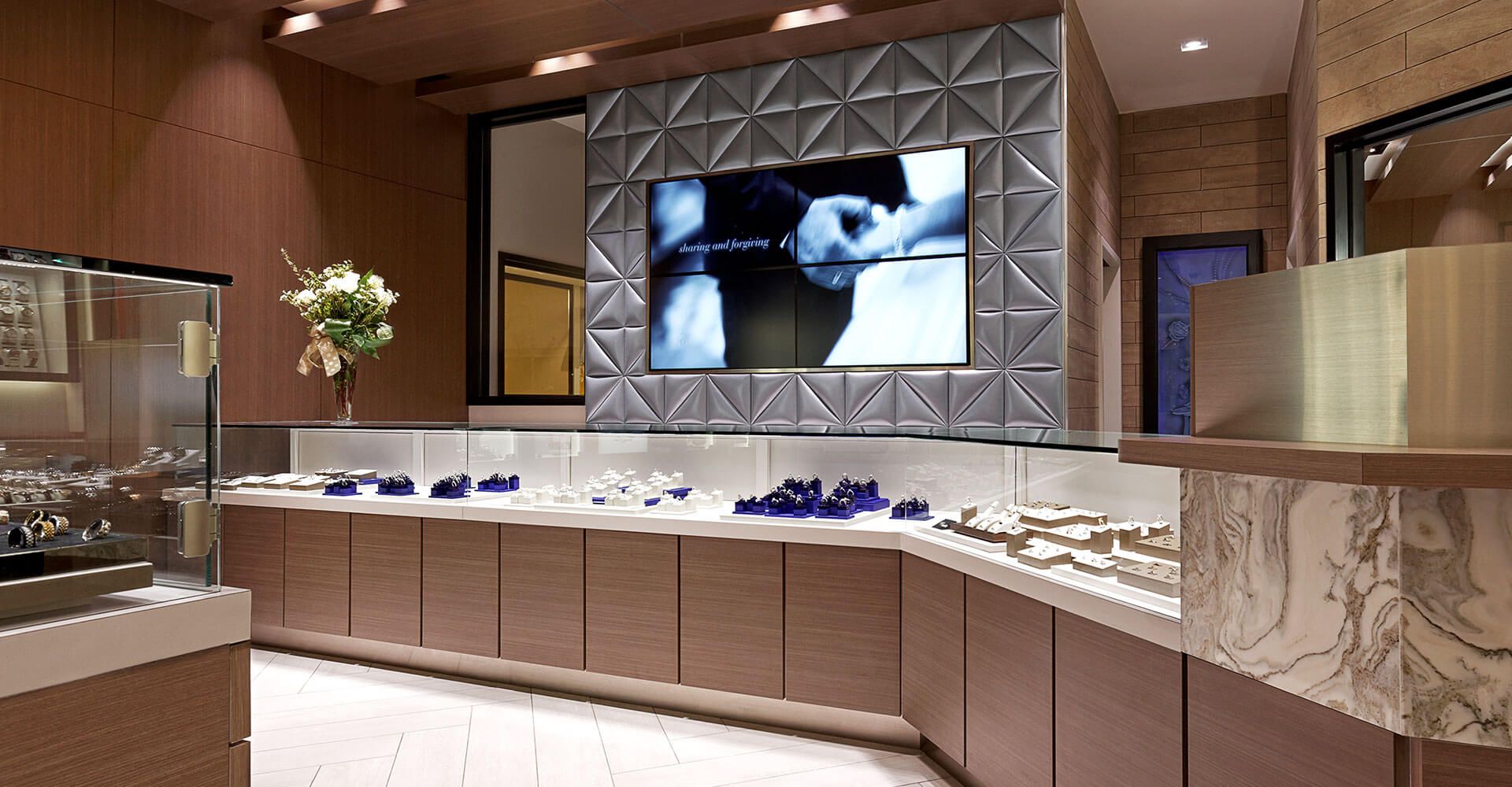 A jewelry store with a large flat screen tv on the wall.